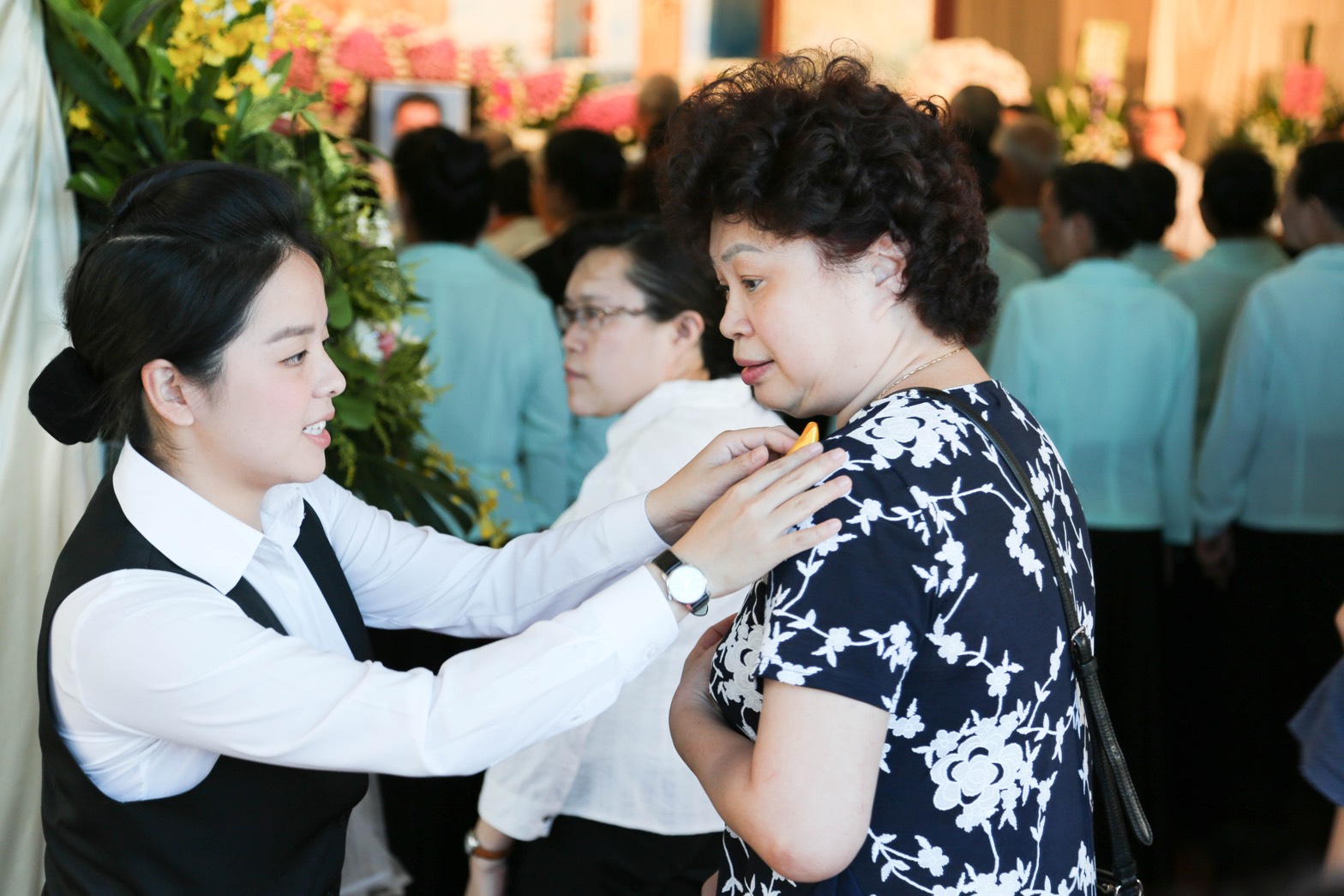 28歲的高上晴（左黑背心者）從小就接觸接體、洗身、穿衣、化妝、入殮的工作-