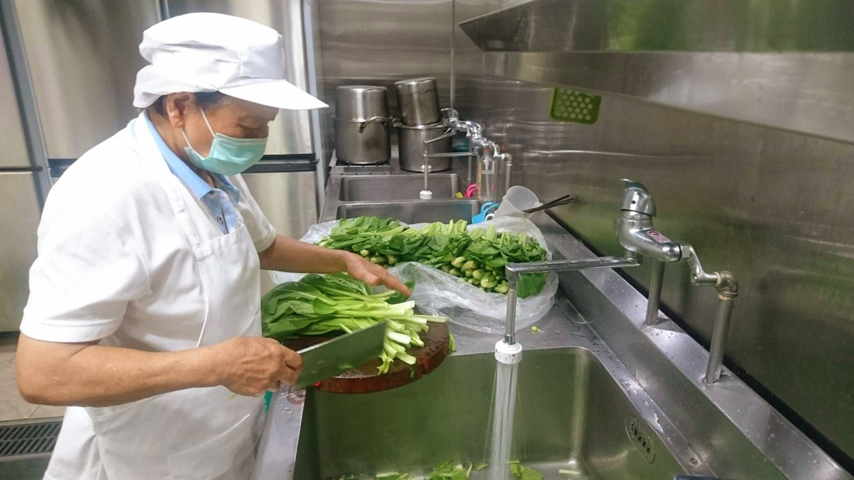 廚房阿姨烹炒有機蔬菜，為農會員工料理美味又健康的午餐