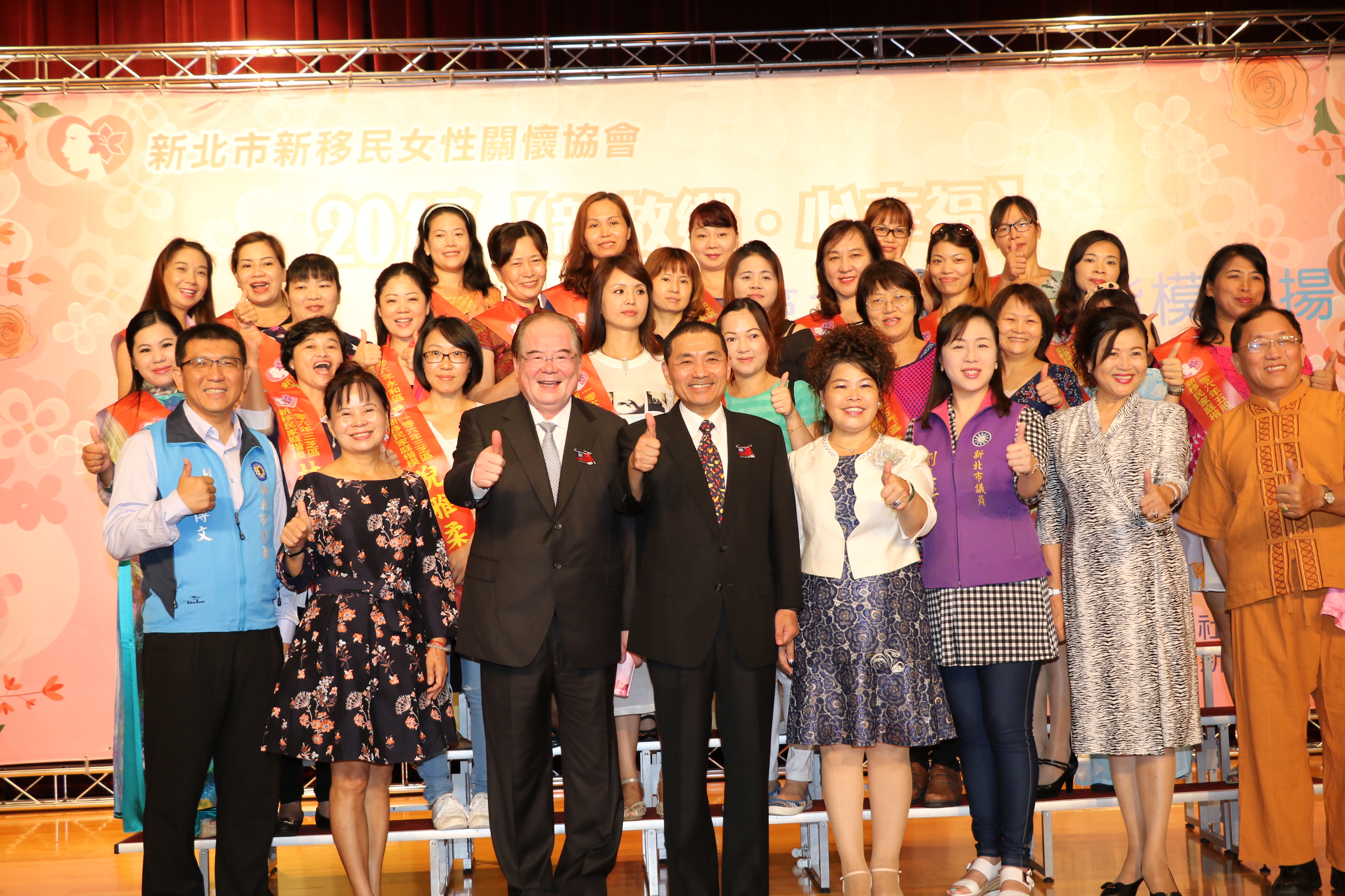 侯友宜和李金菊理事長（前排右4〉一起和27位獲獎的新住民楷模合影