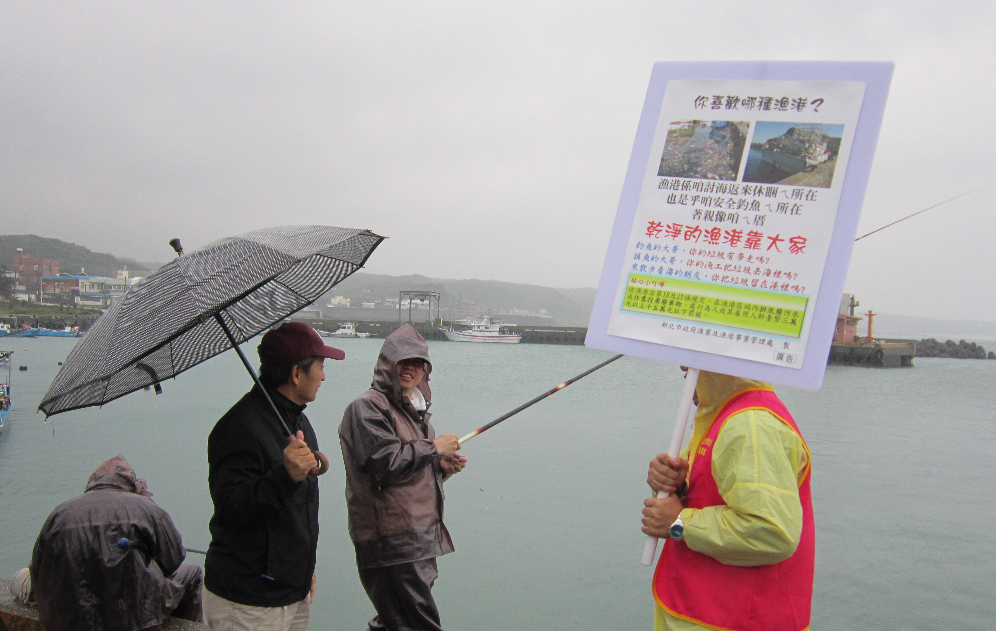 市府人員正向釣客宣導維護漁港整潔.jpg
