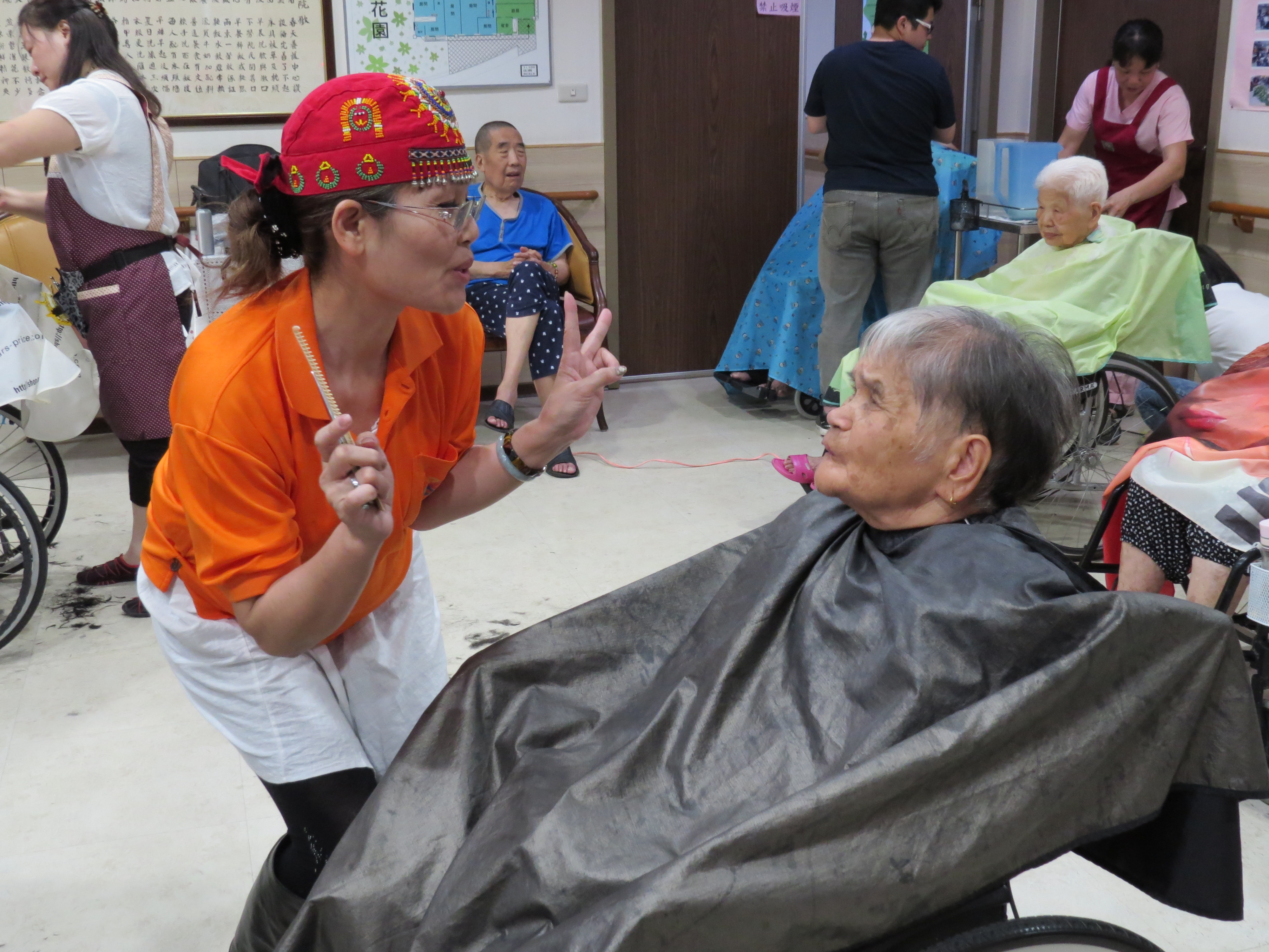 市場攤商不僅幫老人家們剪頭髮，更逗老人家開心。.JPG