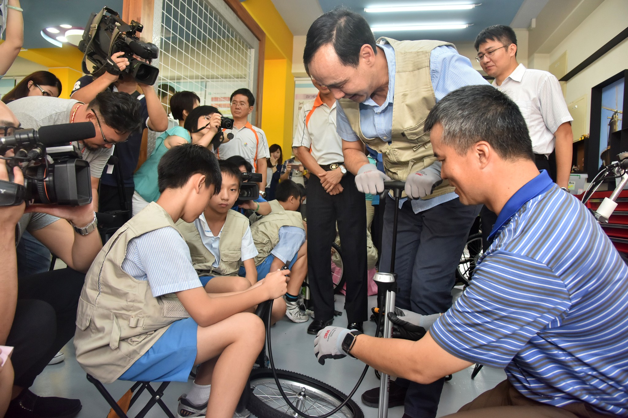 朱市長一同與學童為電動自行車輪胎打氣