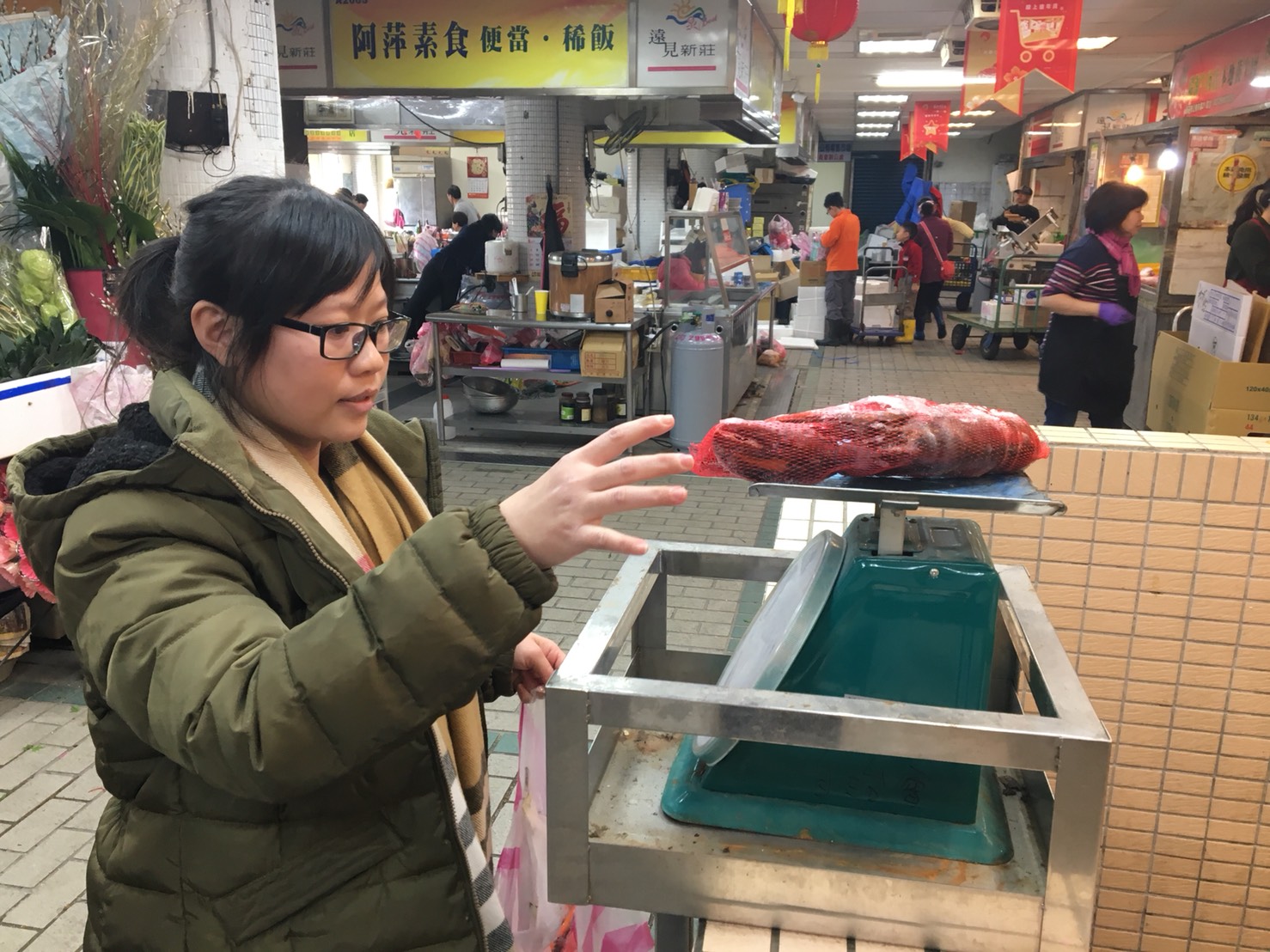 新莊市場採買的陳太太用市場公秤為剛採買的漁貨秤重