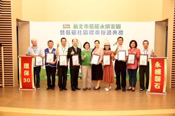環保副局長王美文(左5)與獲得低碳社區標章「銀鵝級」標章的社區代表合影留念.jpg