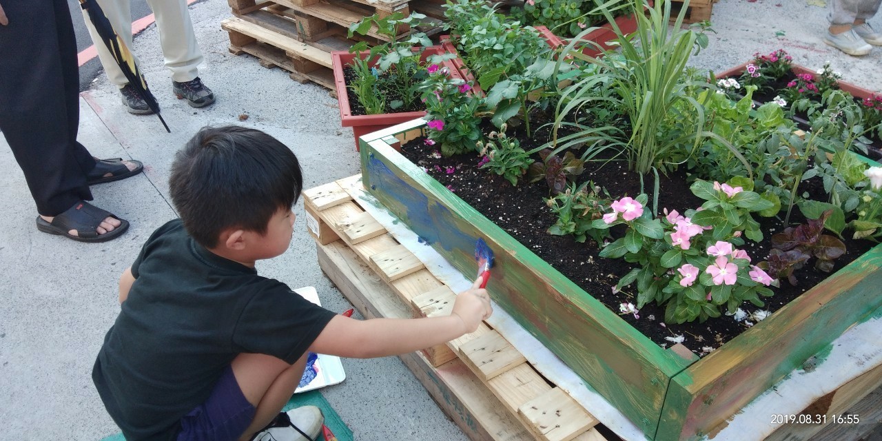 小朋友在花圃上彩繪塗鴉作為裝飾