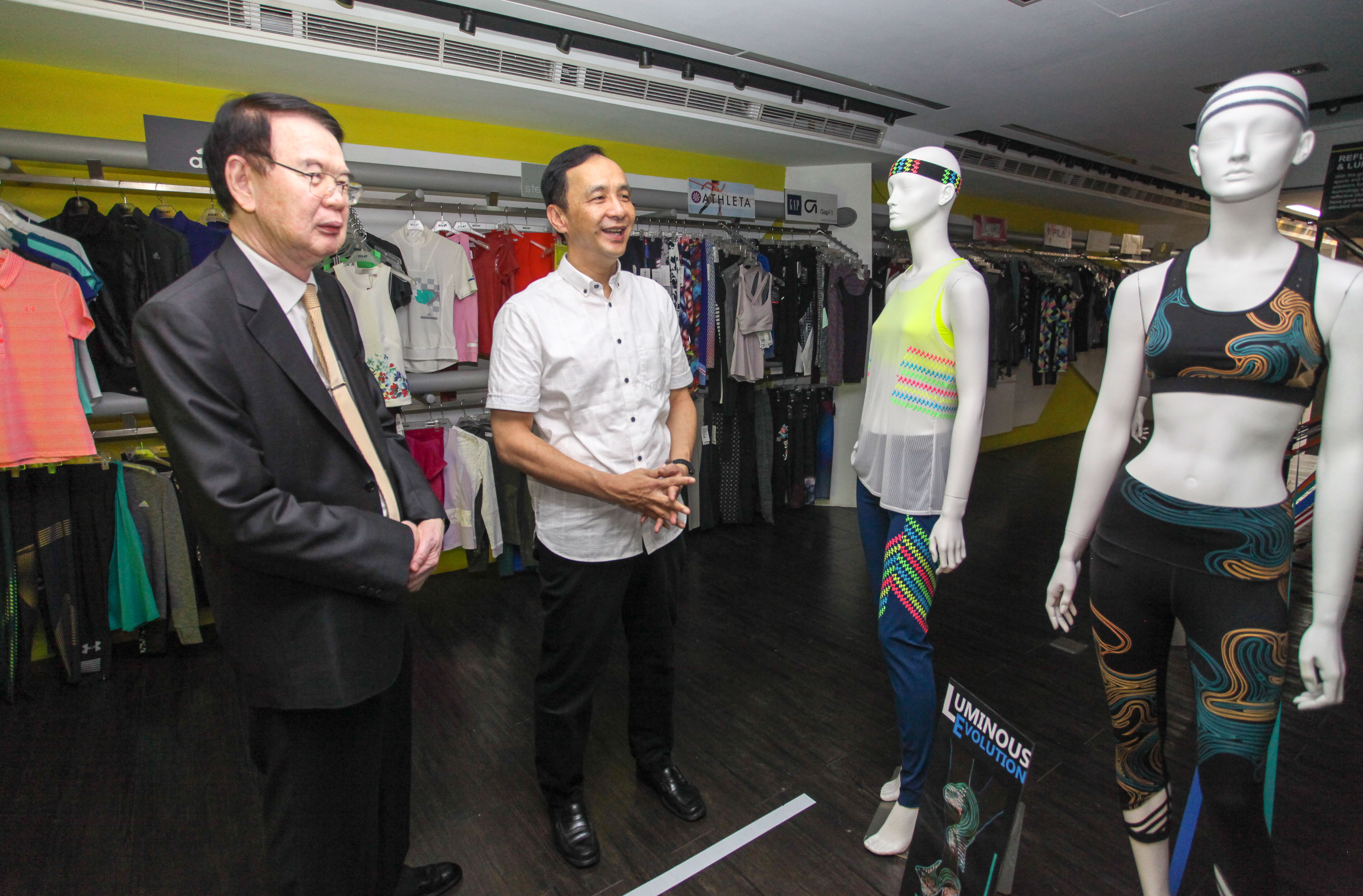儒鴻企業董事長洪鎮海(左)為新北市長朱立倫(右)介紹夜間反光機能衣