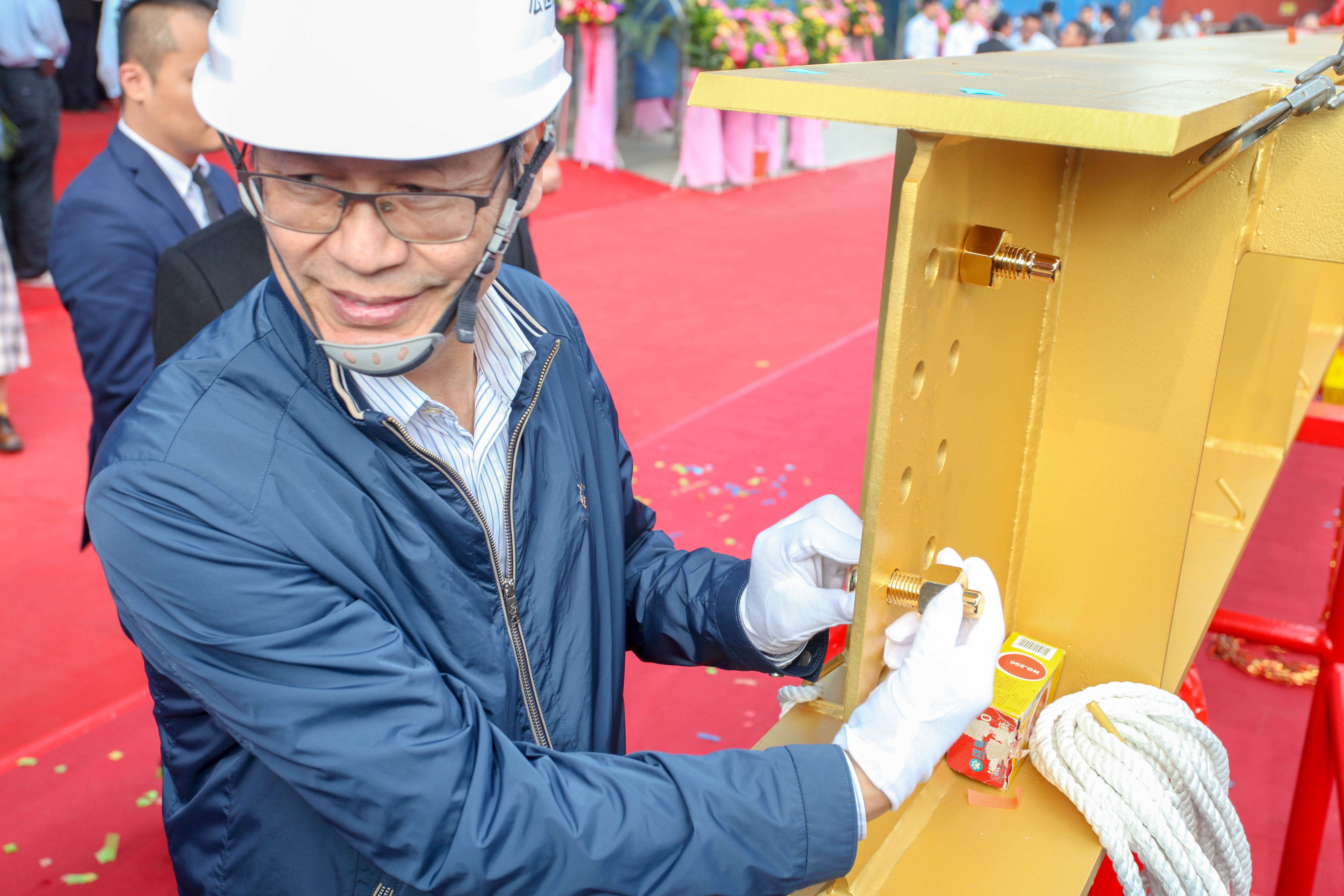 宏匯集團董事長許崑泰為梁柱鎖上金螺栓