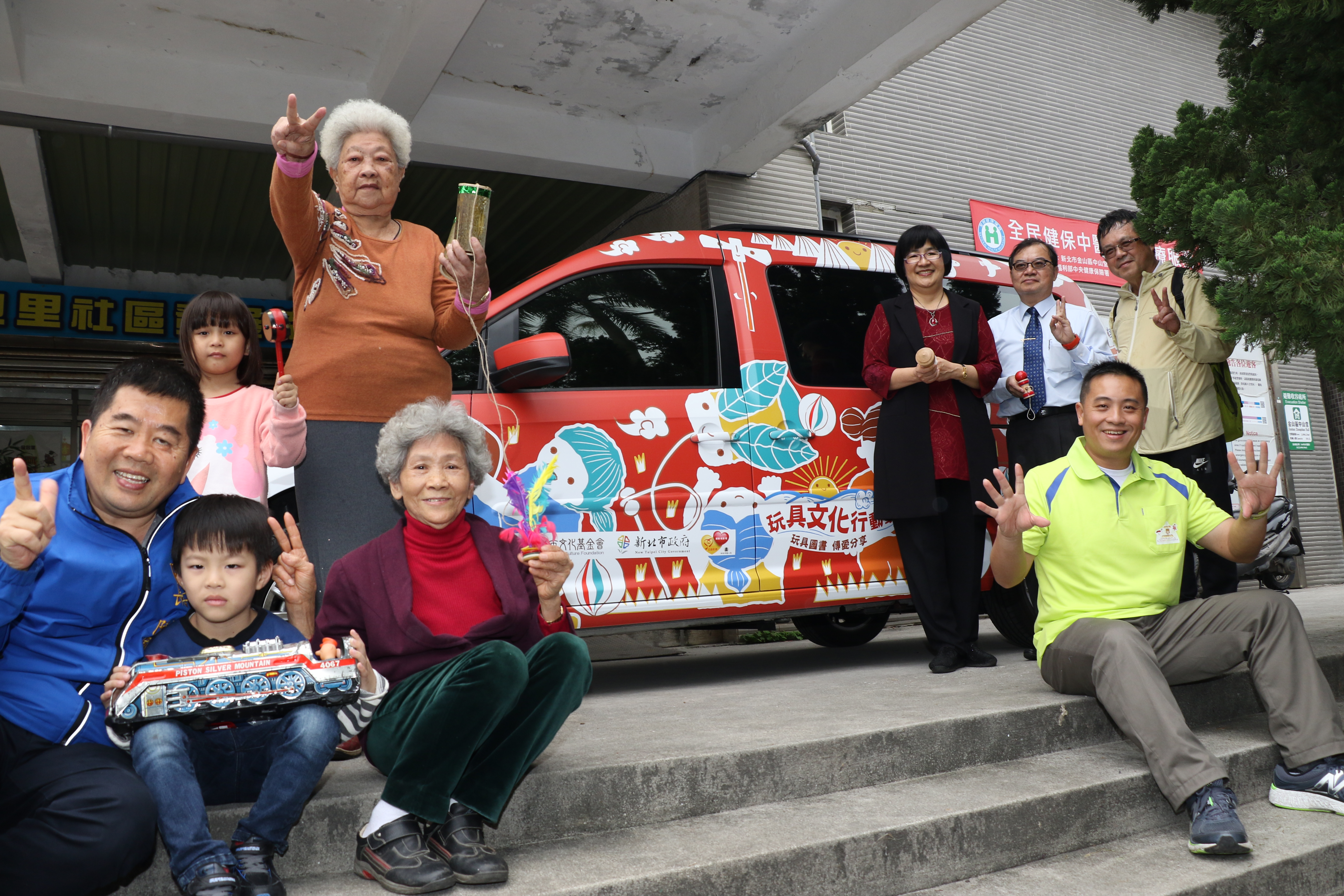 社會局長張錦麗〈右後起〉和新北市文化基金會秘書長林全洲及台灣玩具圖書館協會理事長葉國芳、金山區長陳國欽〈左1〉等人一起啟動玩具行動車