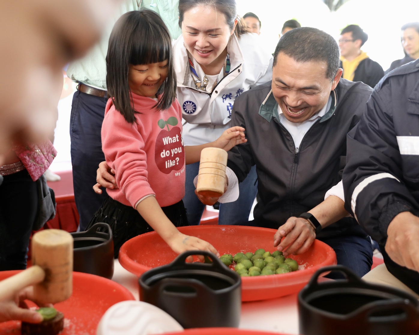小女孩與新北市長侯友宜合力拍裂青梅。