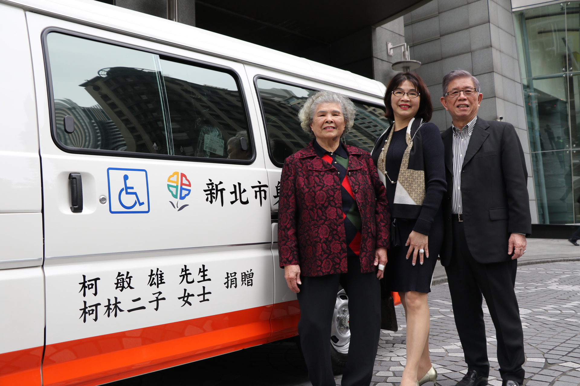 柯鈺羚（中）與先生林登裕帶著媽媽柯林二子〈左〉捐贈新北市政府復康巴士