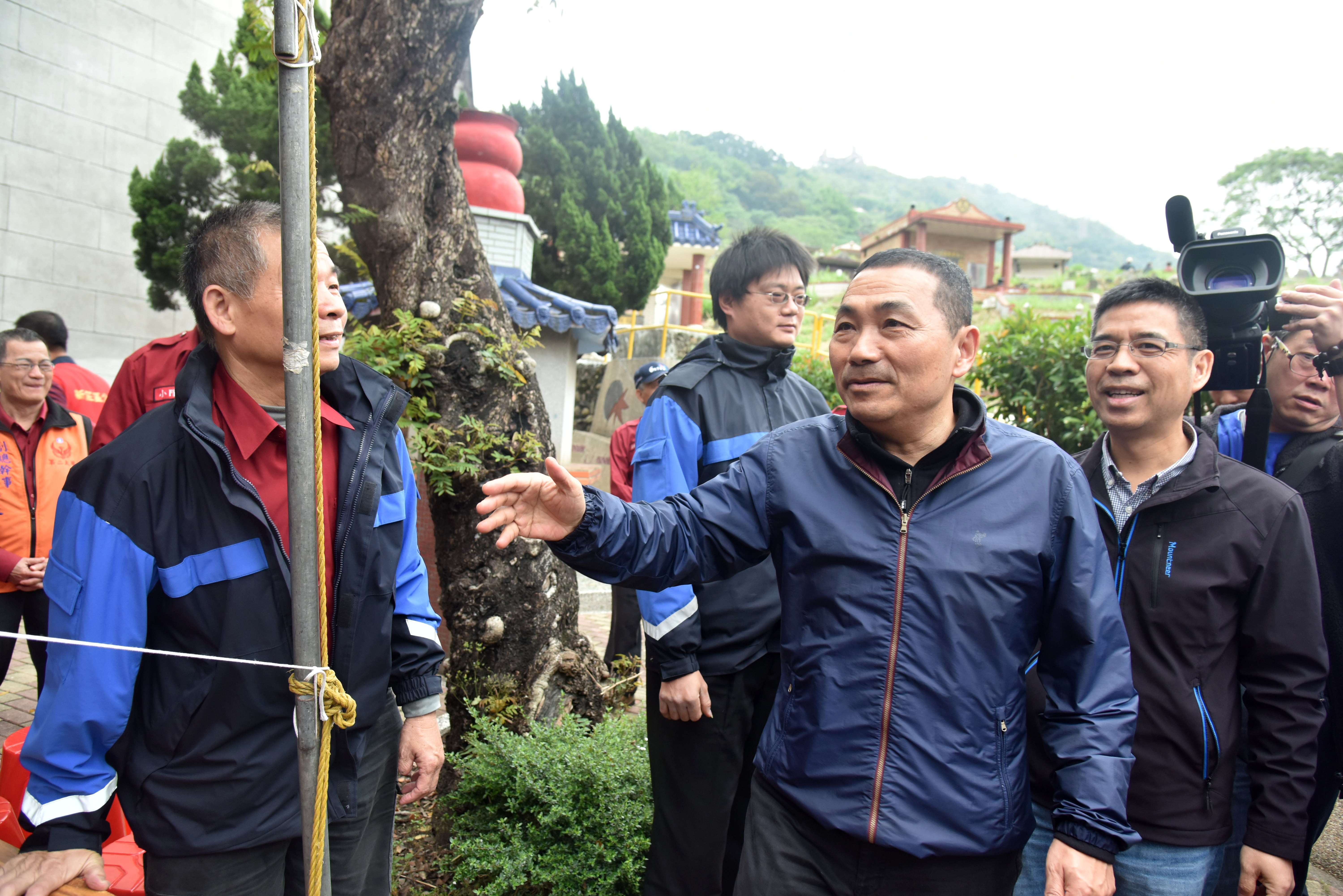 新北市長侯友宜（右二）與民政局長柯慶忠（右一）一早連趕兩地上香祭祀，並與掃墓民眾握手互動。
