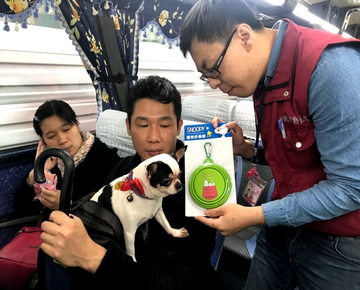 動保員於遊覽車上發放折疊