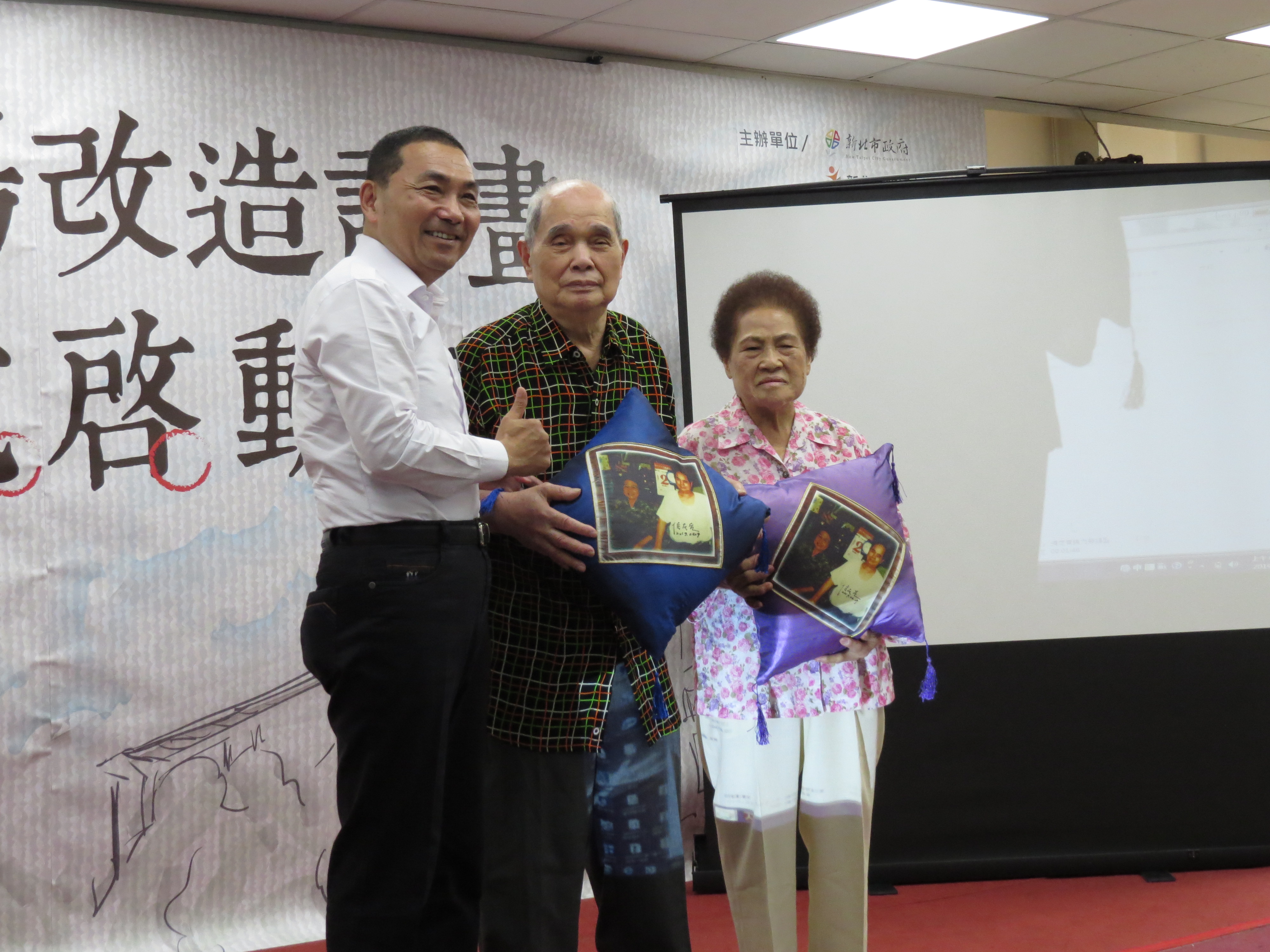 圖說：侯市長特別送上親筆簽名的抱枕給黃石市場第一代的攤商。