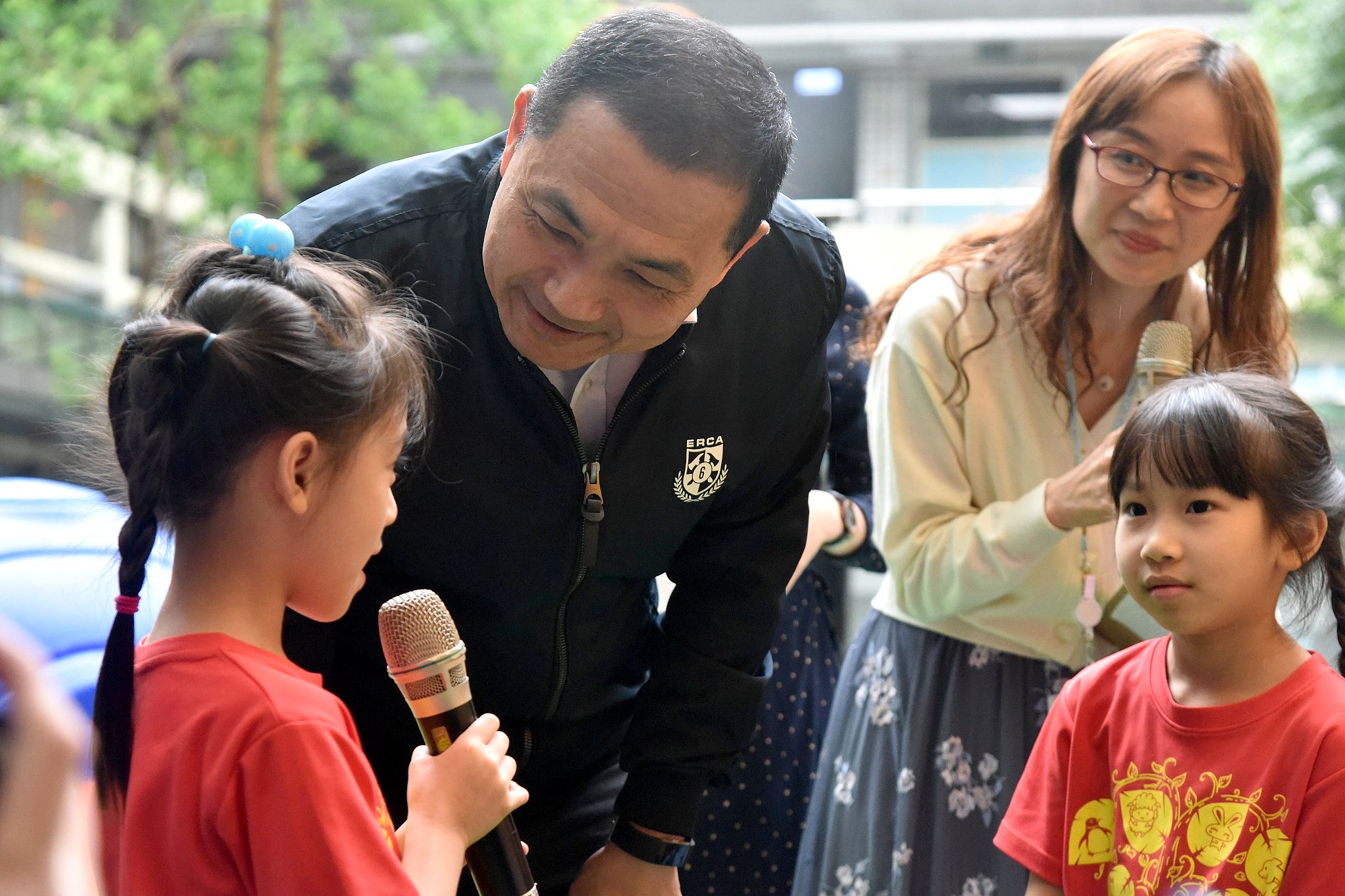 市長專心聽小朋友講解如何安全使用遊戲場設施