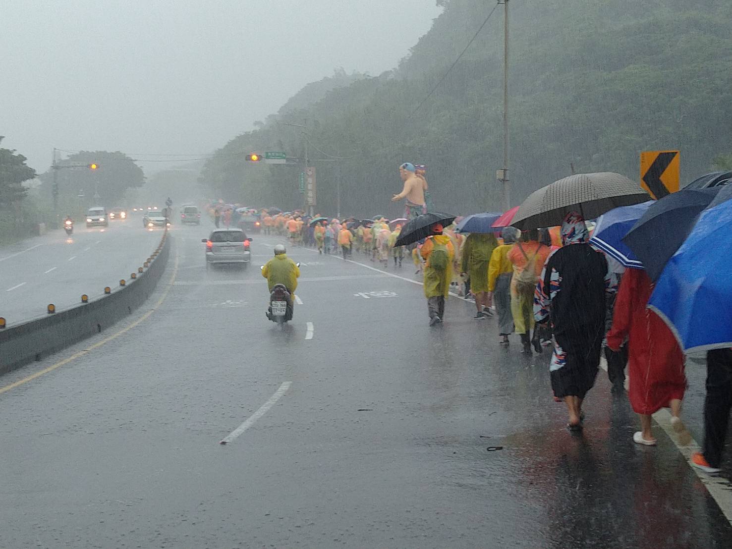 今天早上大雨不斷，虔誠信徒仍穿雨衣徒手接力傳接「出巡媽」，陪二媽回娘家。
