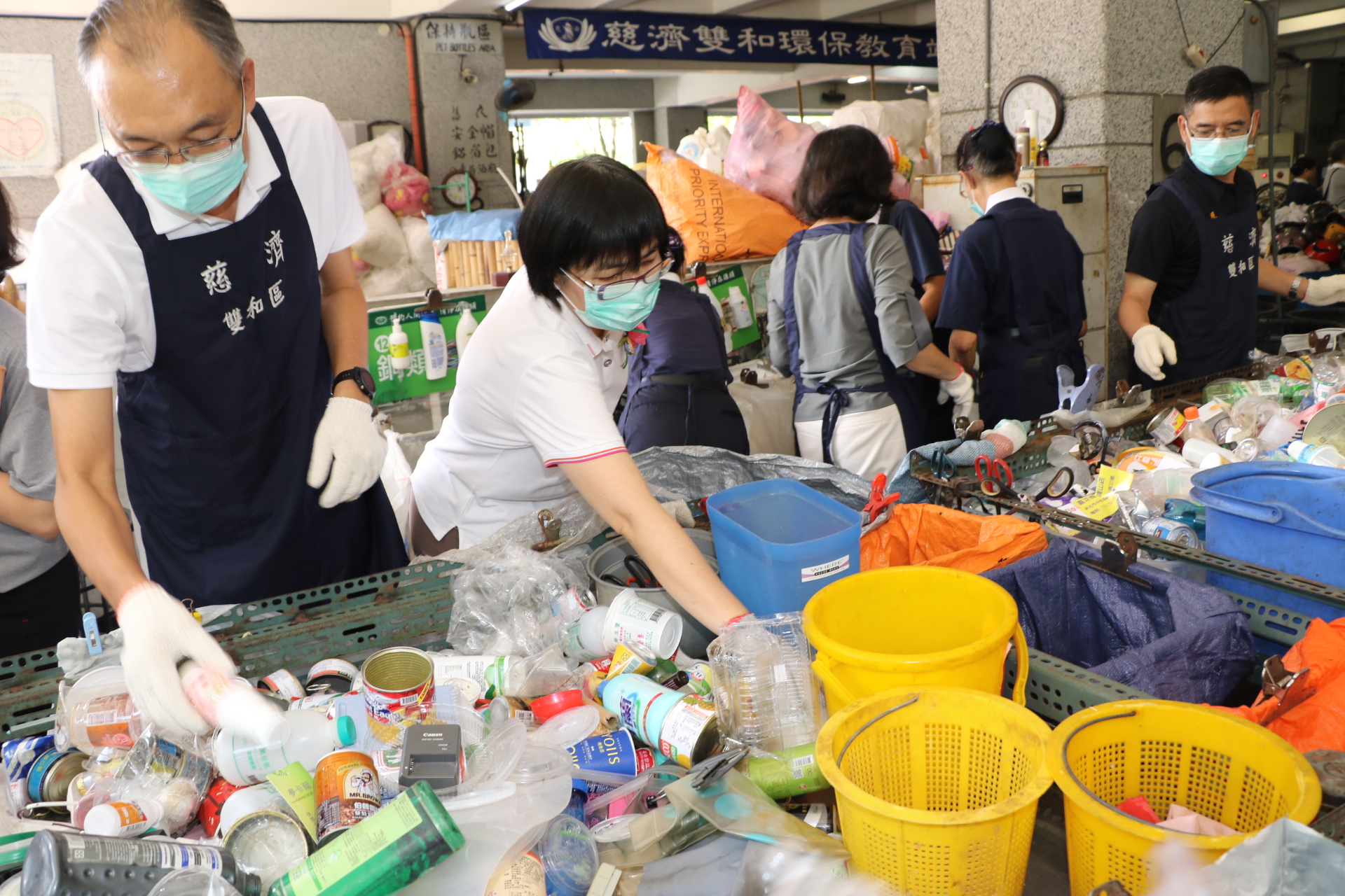 謝政達（左1）和社會局長張錦麗（左2）等人動手做資源回收分類