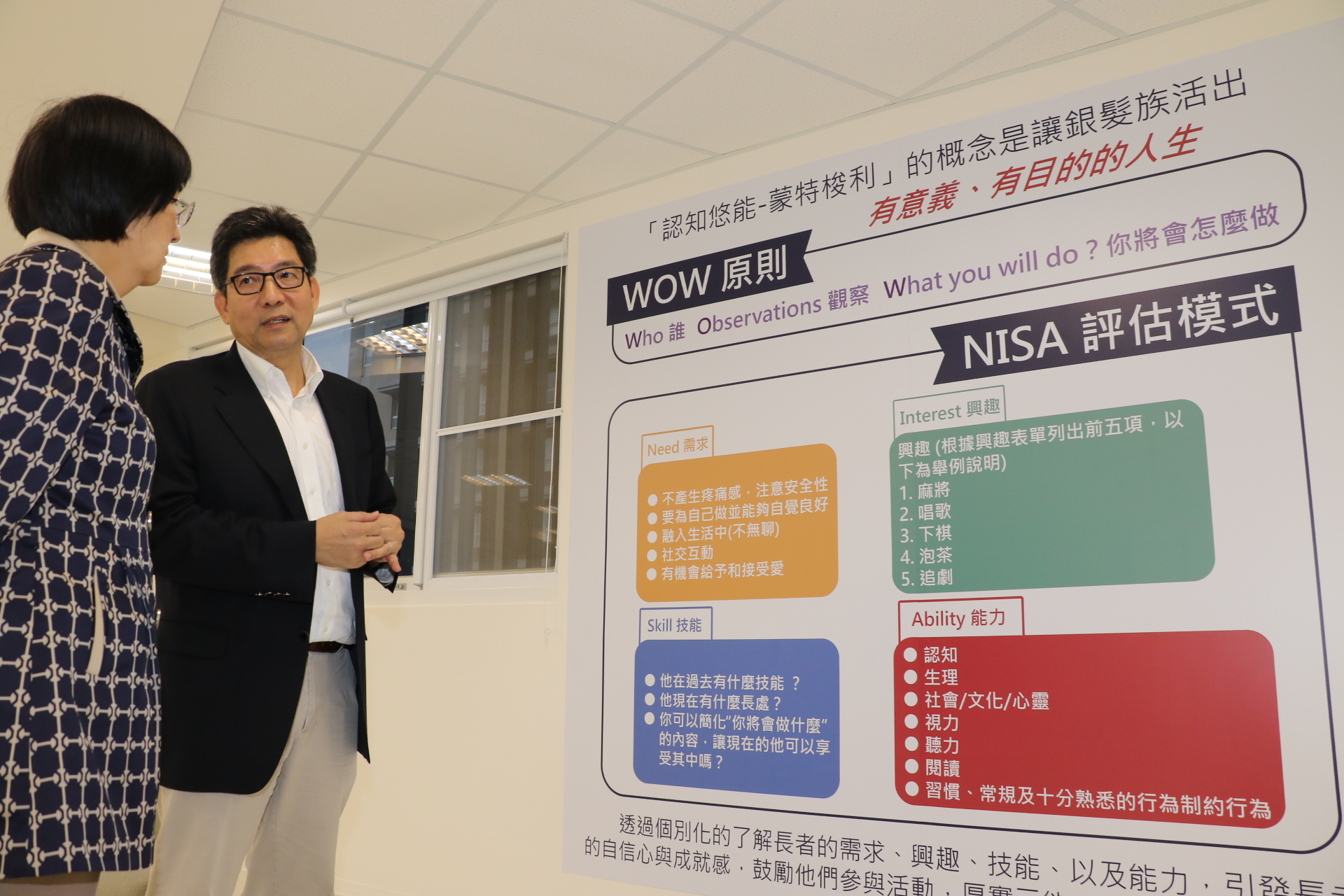 台灣認知功能促進協會理事長甄瑞興（右）向張錦麗局長解說認知悠能蒙特梭利照顧原理