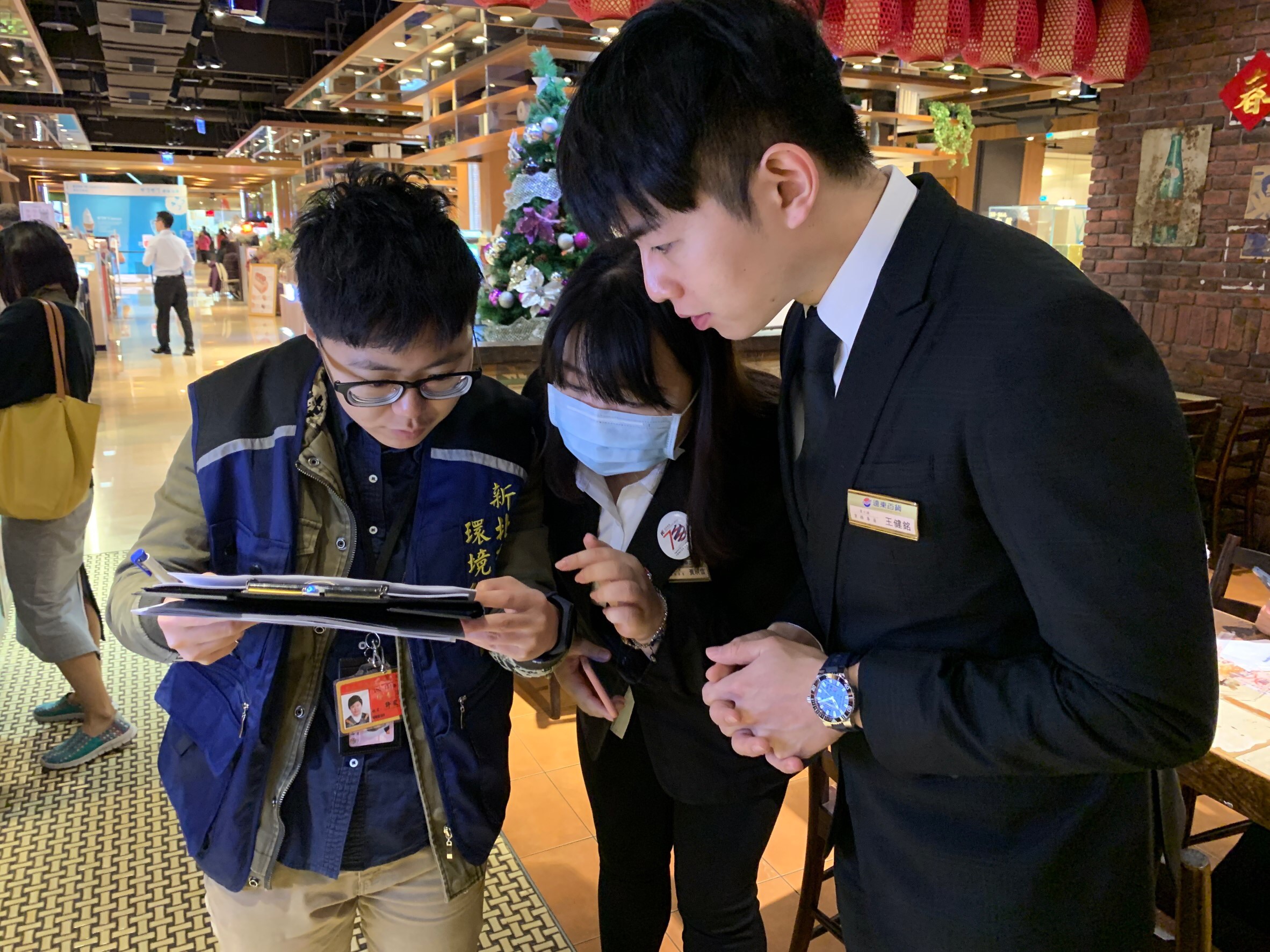 稽查員向百貨公司業者說明擴大限用免洗餐具政策