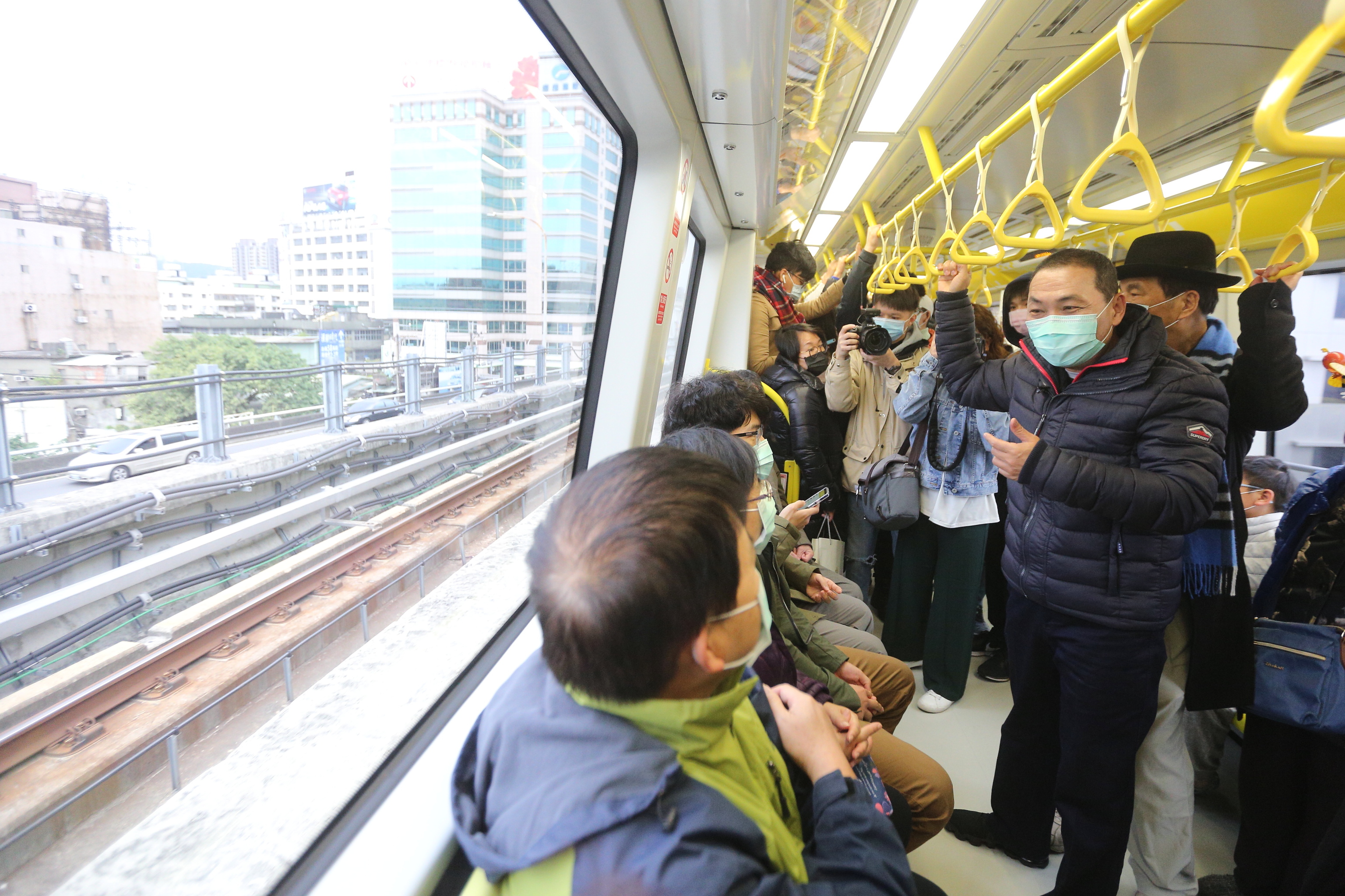 侯友宜市長視察環狀線春節試乘情形，在車廂內與民眾拜年並宣導防疫注意事項。