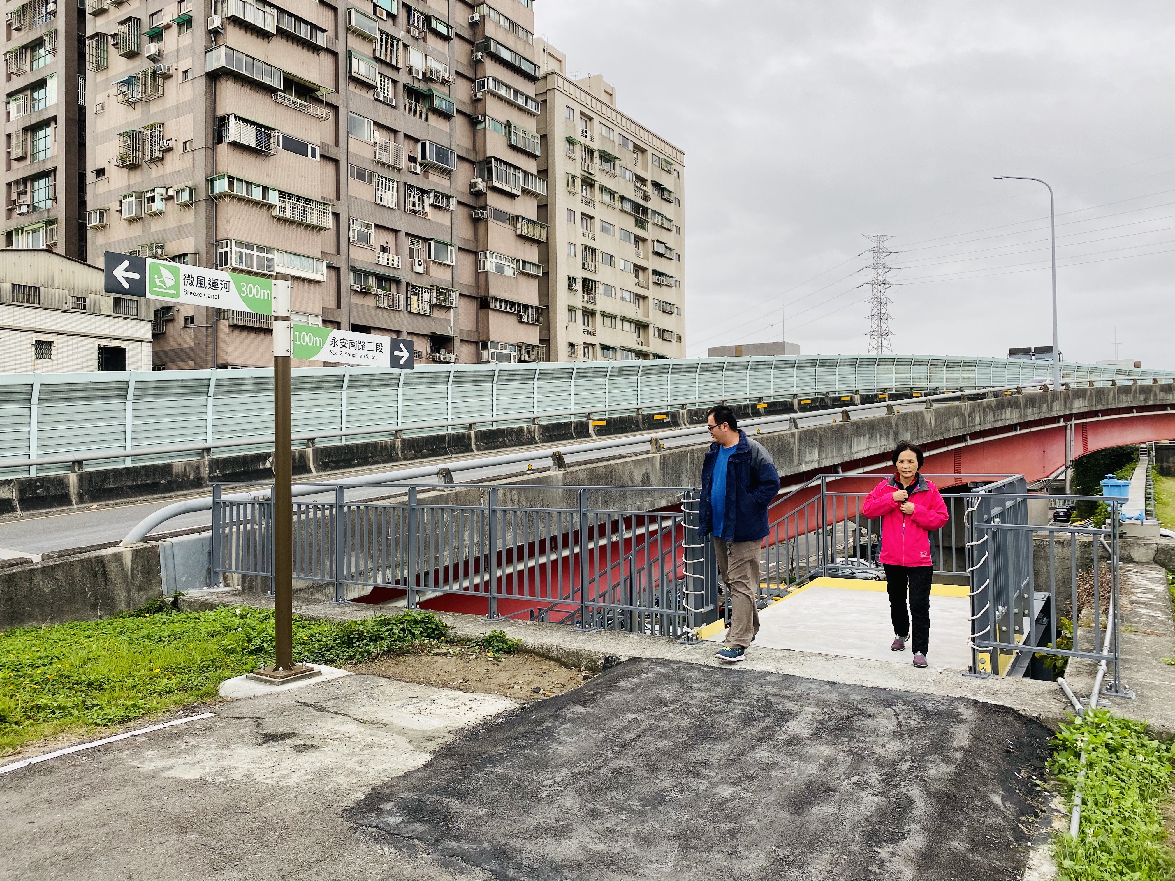 於停車場角落設置一座跨堤階梯通往堤頂，期望藉由階梯設置得順利銜接市區民眾及停車場出入河濱動線，完整串連堤內外空間
