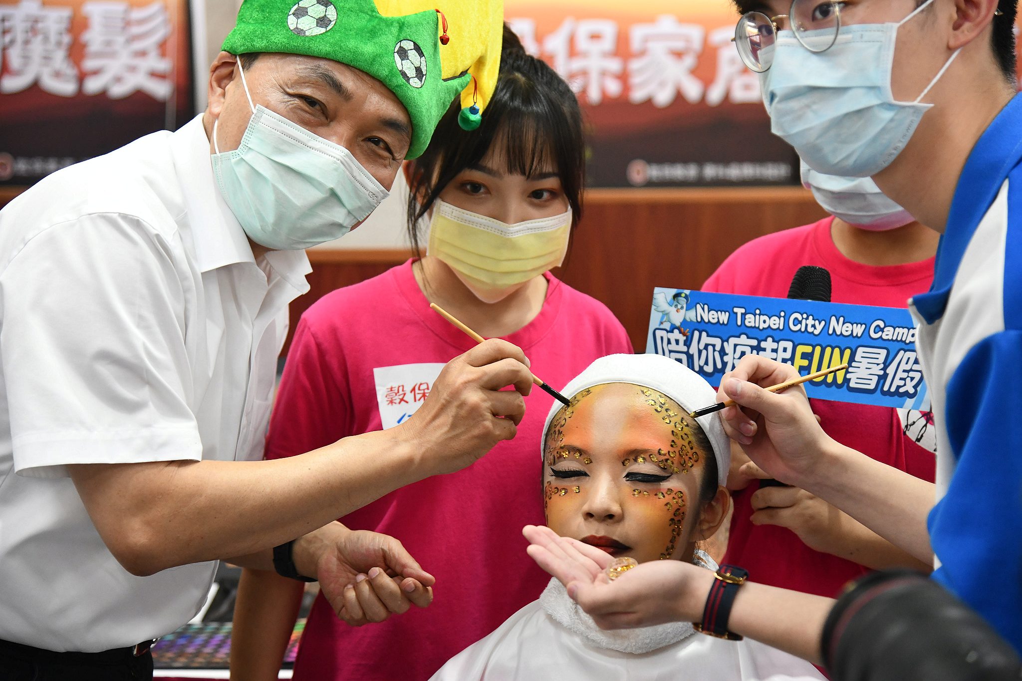 市長侯友宜也在暑期學生育樂營報名記者會上，試做巧克力球、體驗編髮及人體彩繪。