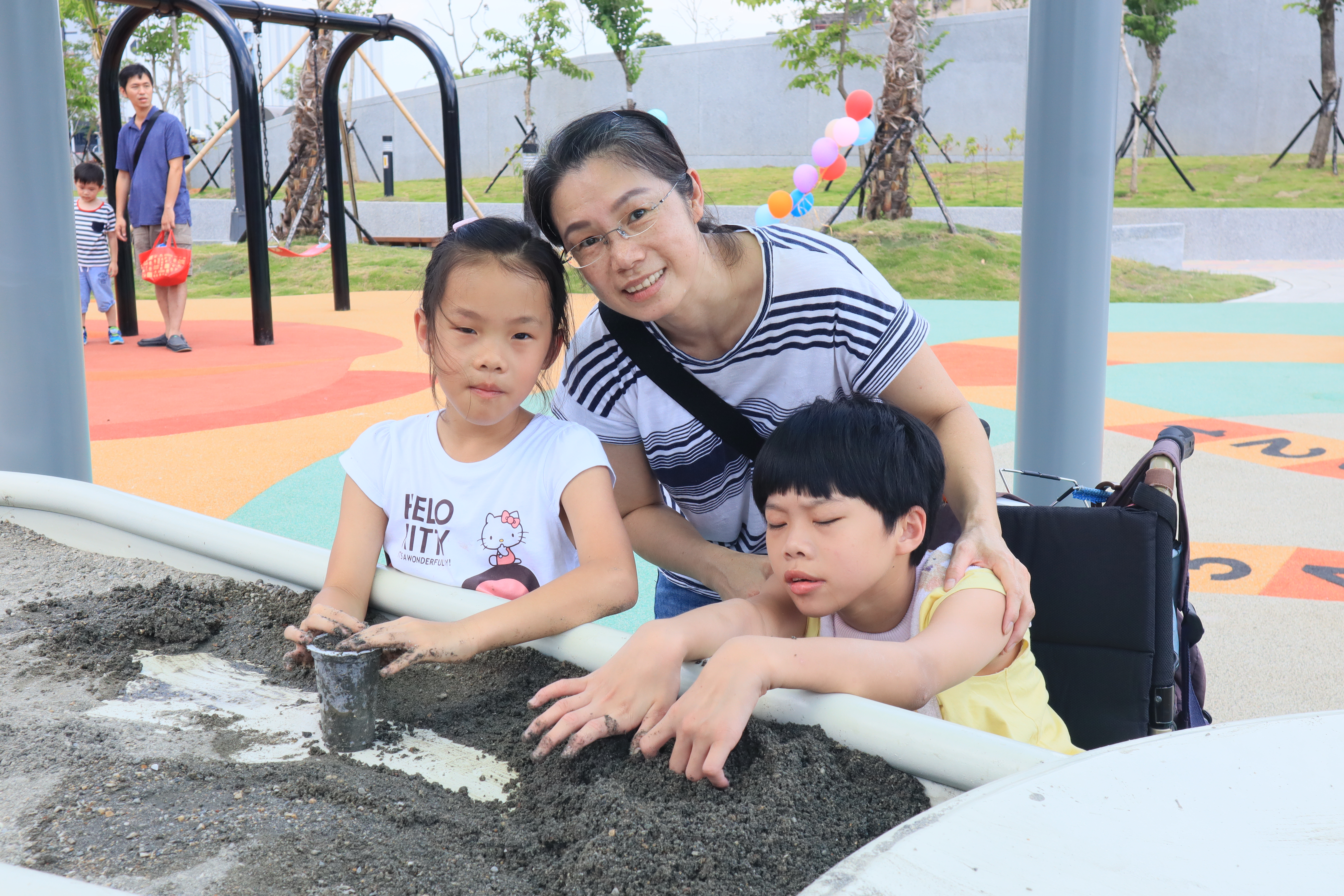 二重埔市民活動中心及具有共融性特色的二重公園一起開放啟用，小朋友在沙桌旁站著就玩起沙來，特別開心。