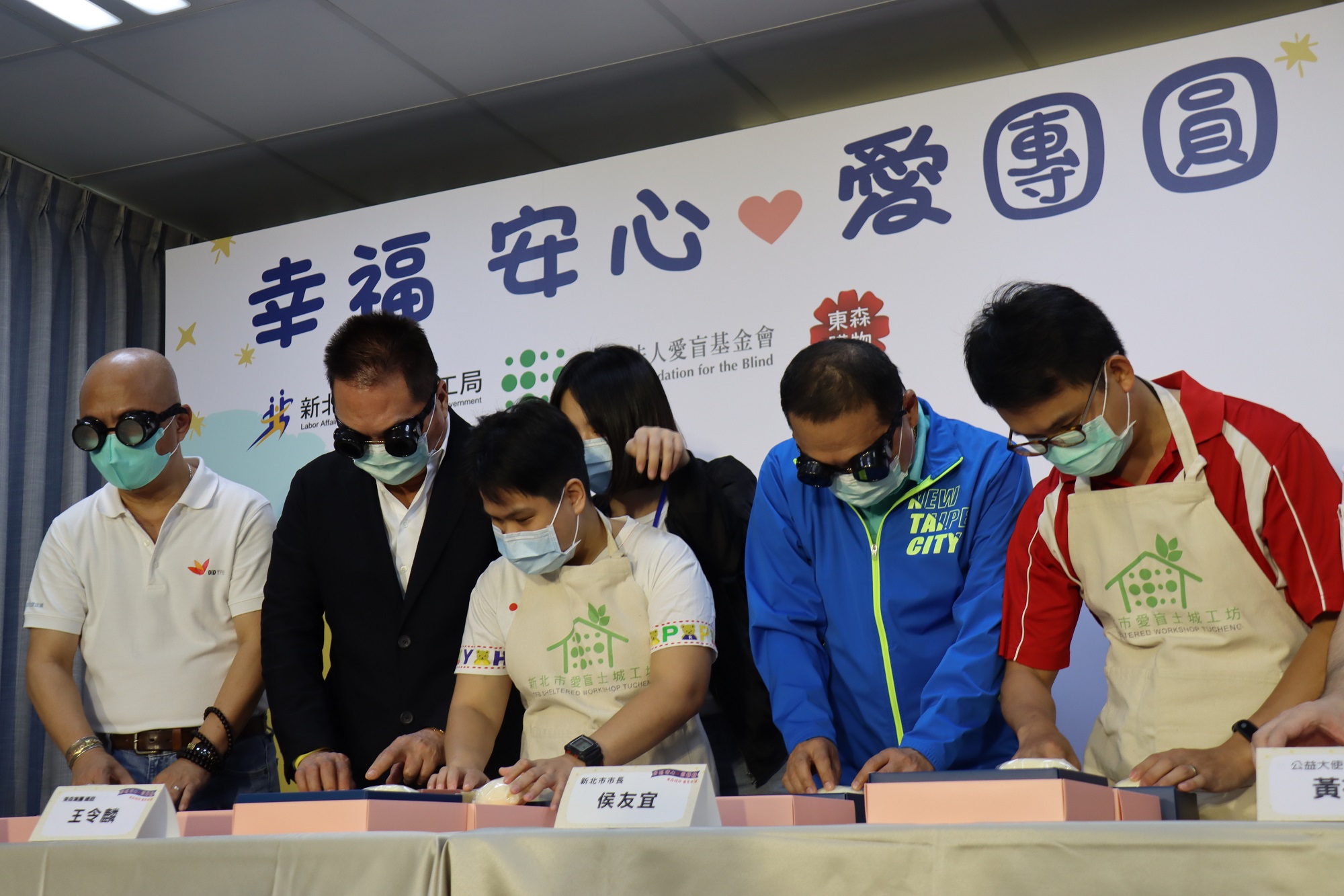 市長侯友宜(右2)、愛盲董事長謝邦俊(左1)、東森總裁王令麟戴(左2)視障模擬眼鏡體驗手工