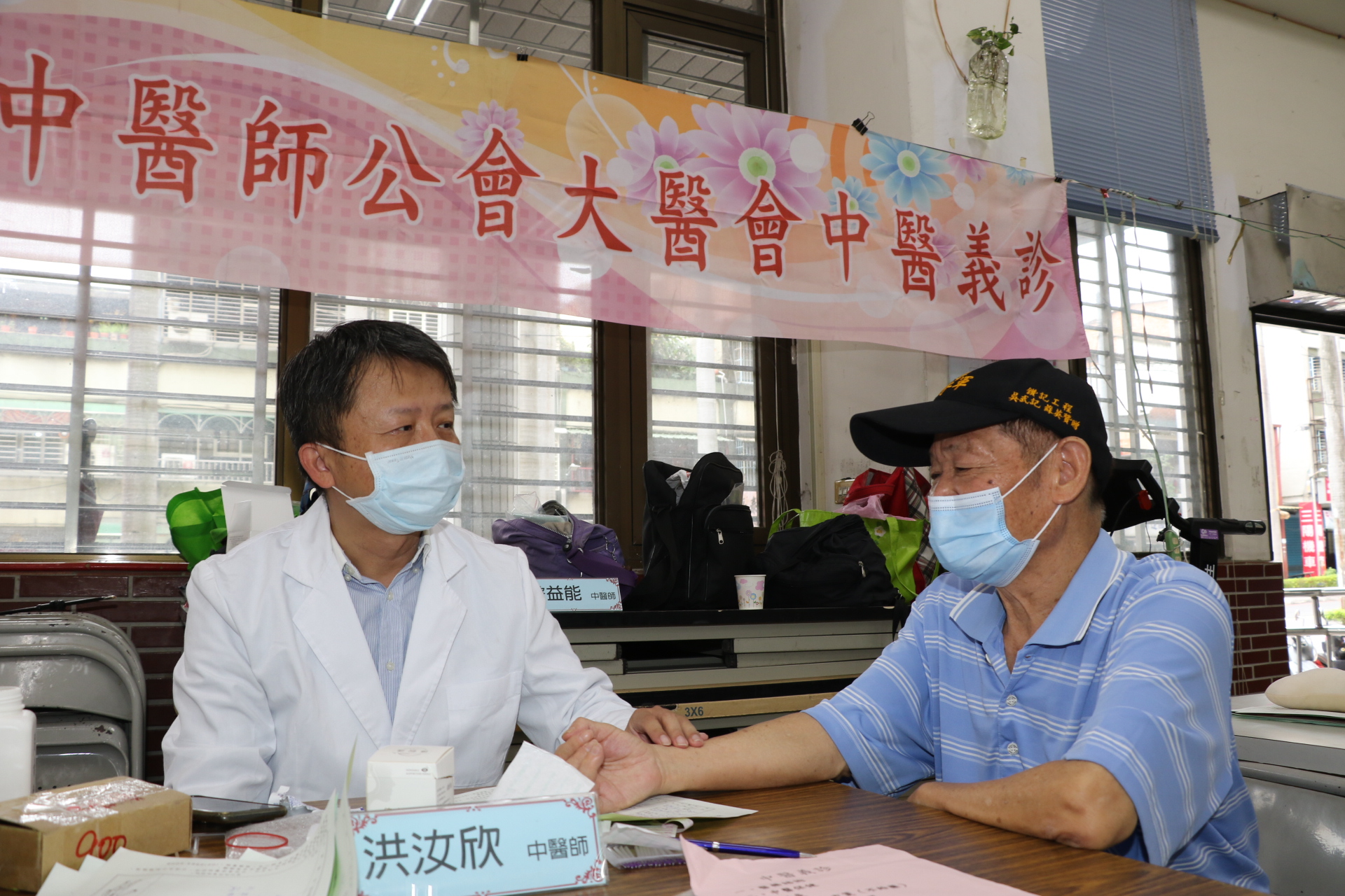 新北中醫師公會中醫師在現場為長輩把脈針灸