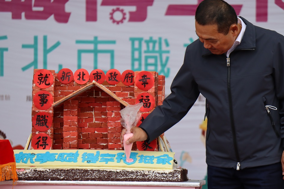 市長侯友宜在象徵「幸福抵『家』」的餅乾屋畫愛心