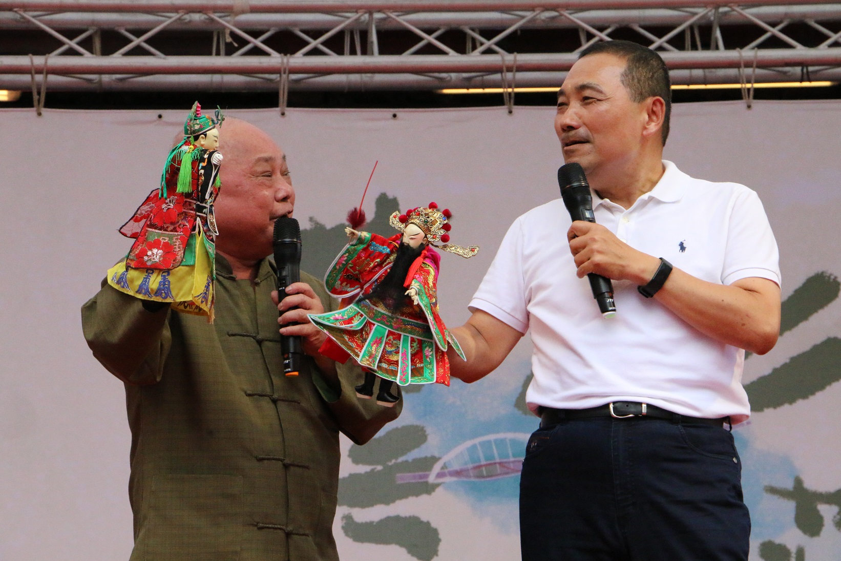 新西園掌中劇團第三代團主許正宗(左)傳授市長侯友宜(右)「走路」及「打招呼」的操偶技巧