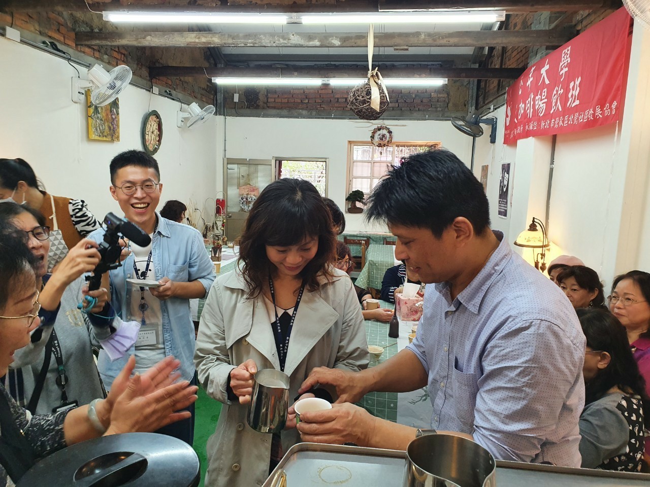 區長施明慧與咖啡老師學習咖啡拉花