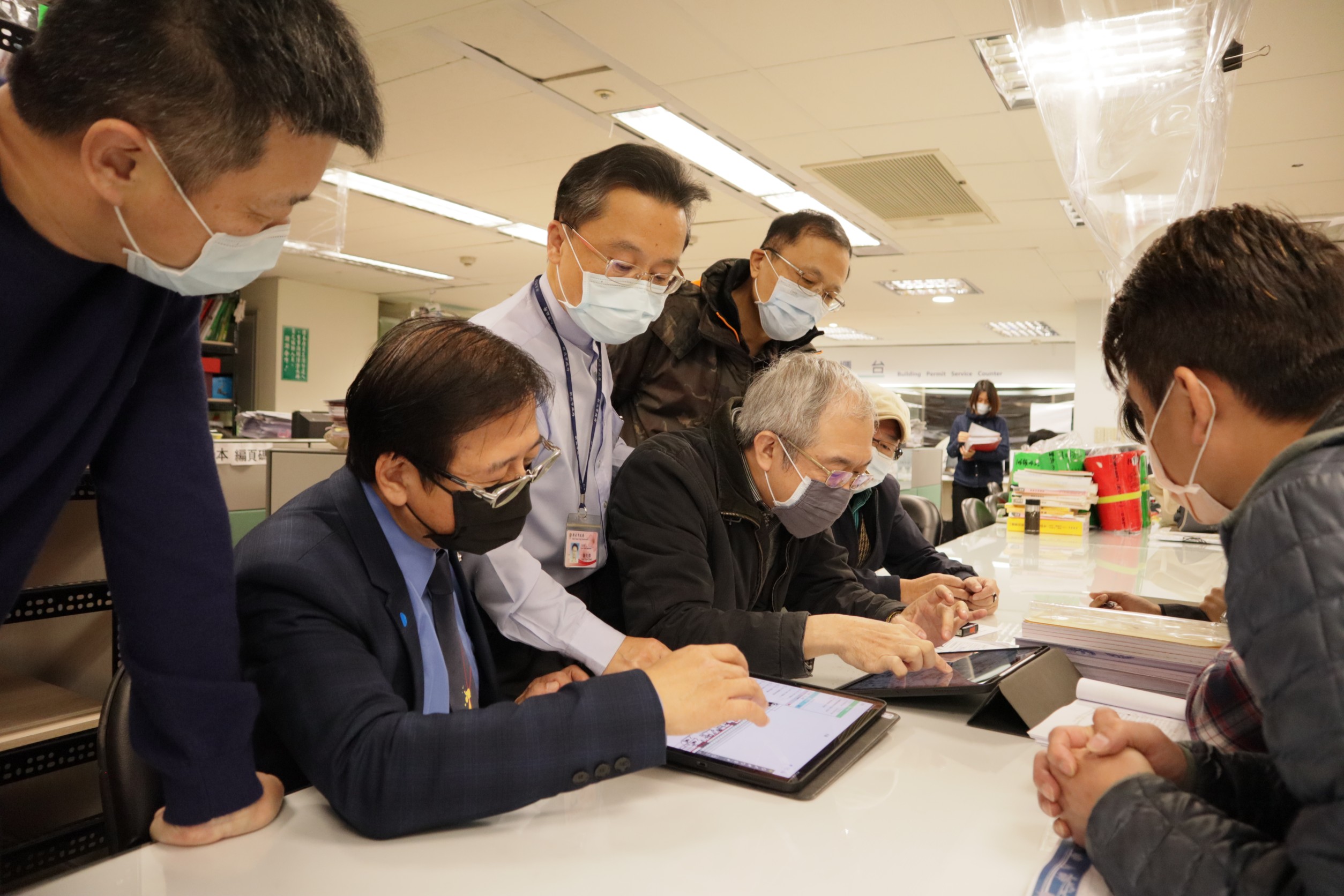 新北市工務局副局長郭俊傑（站立穿淺色襯衫者），前往建照協審室，了解建築師公會如何協助新北市府推動無紙化政策