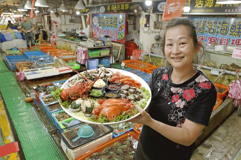圖四：富基攤商手持料理好的海鮮拼盤笑臉迎人，歡迎大家電話訂購！