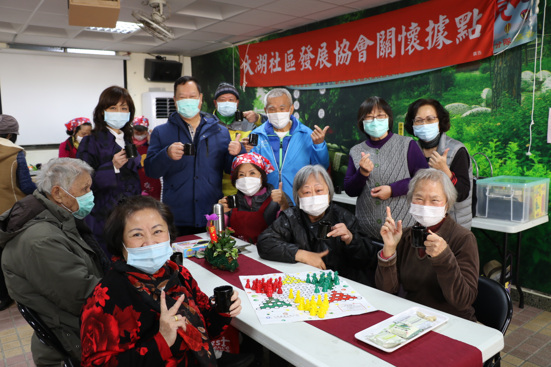 大湖社區每天都排有課程  長輩人手一杯手沖咖啡  左後為鶯歌區長施明慧  前排右3為社區理事長李素貞（頭戴花巾）