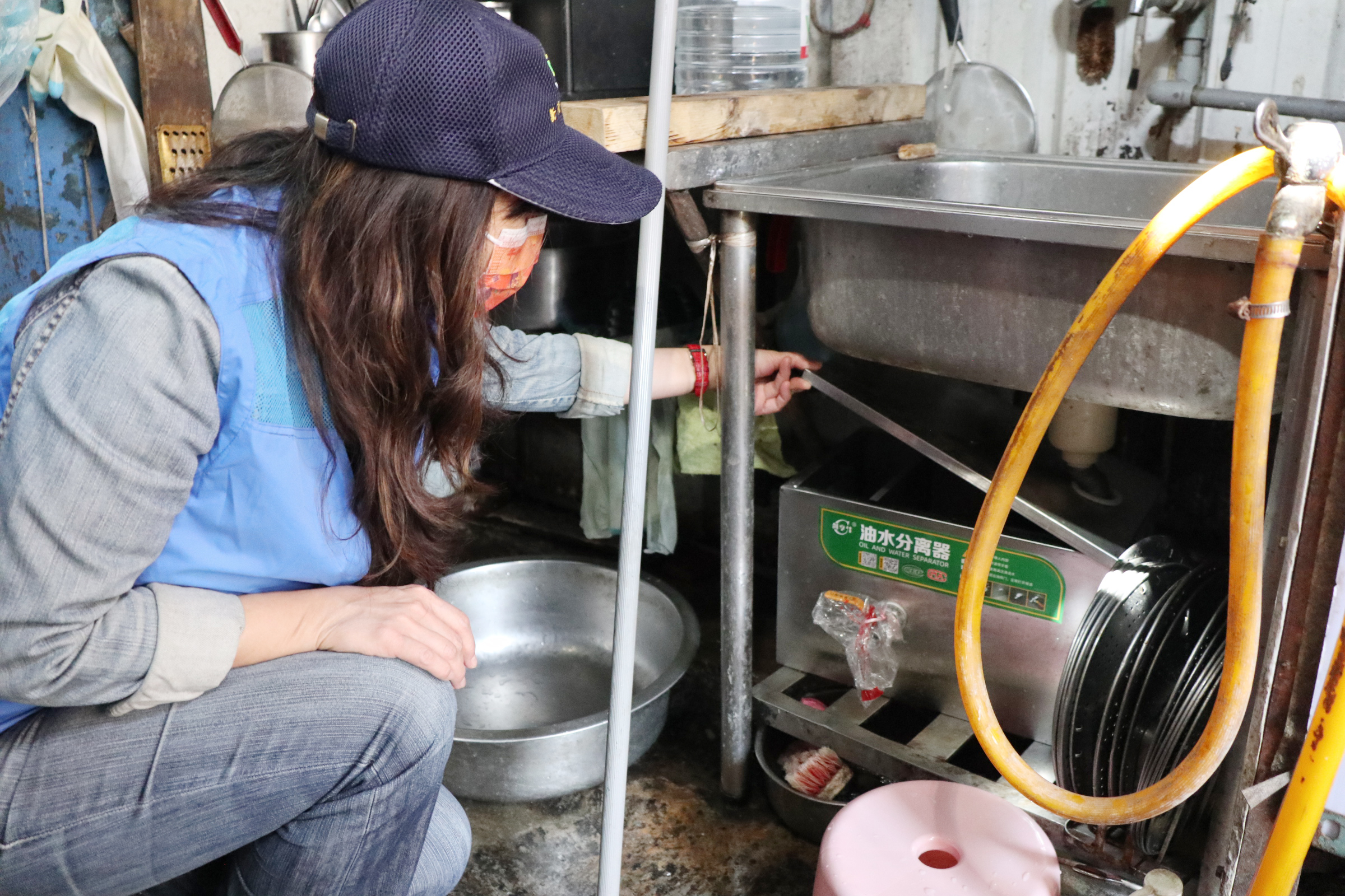 圖說：新北市政府市場處針對永和民治市場裝設油脂截留器情形進行稽查，攤商確實裝設完成並每日清洗機台，為瓦磘溝水質盡一份力。