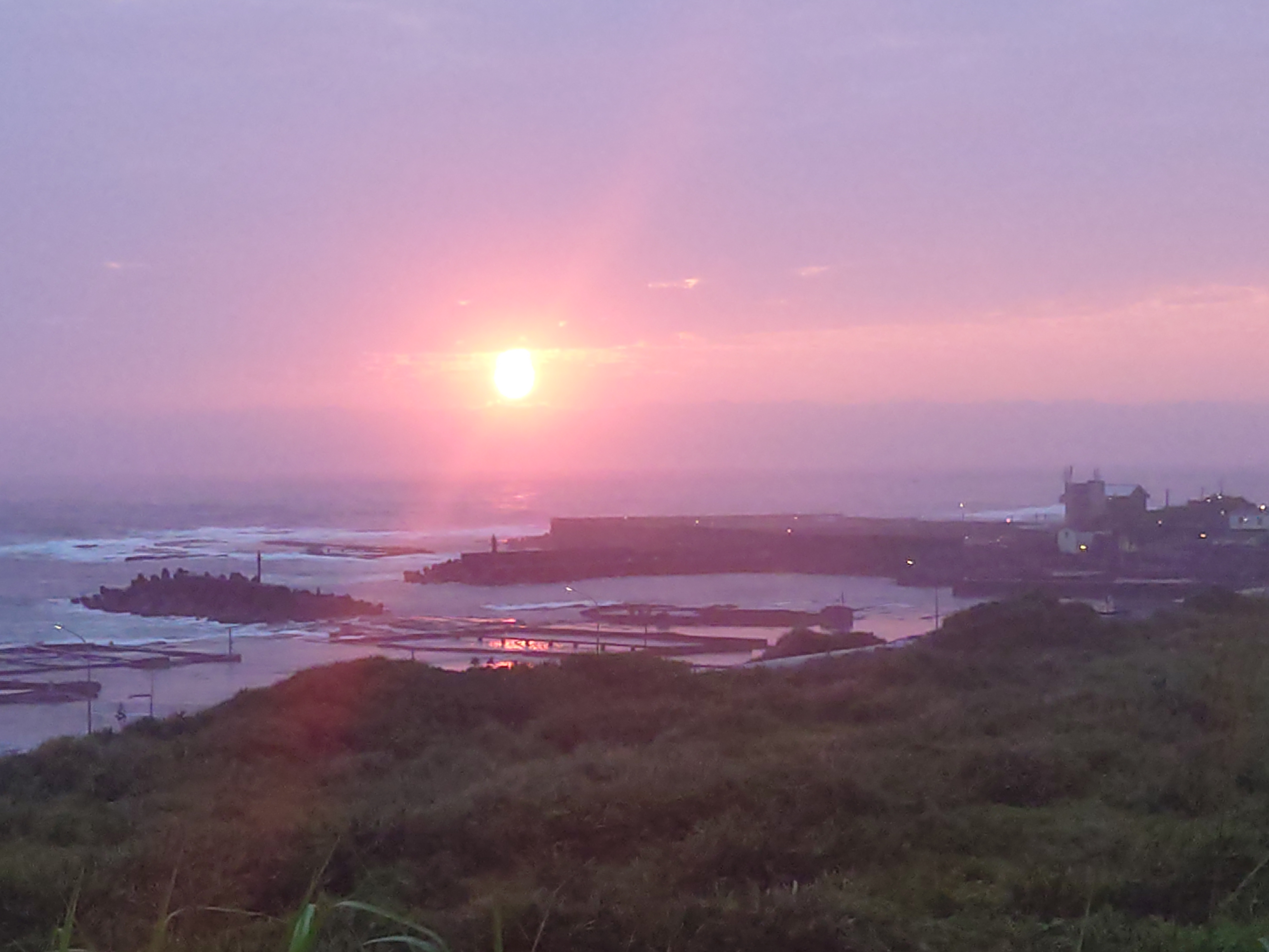 朝陽下的馬崗漁村及貢寮鮑潮間帶養殖池。