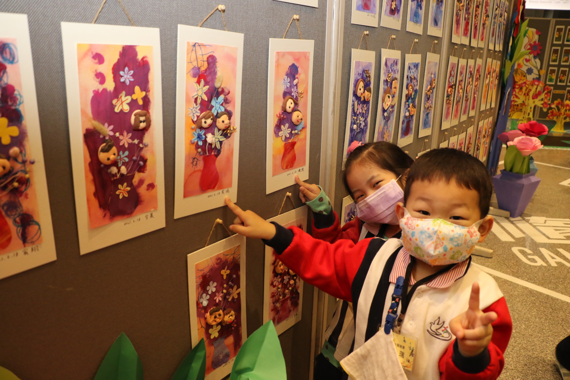 小朋友在眾多畫作中找到自己的作品相當開心