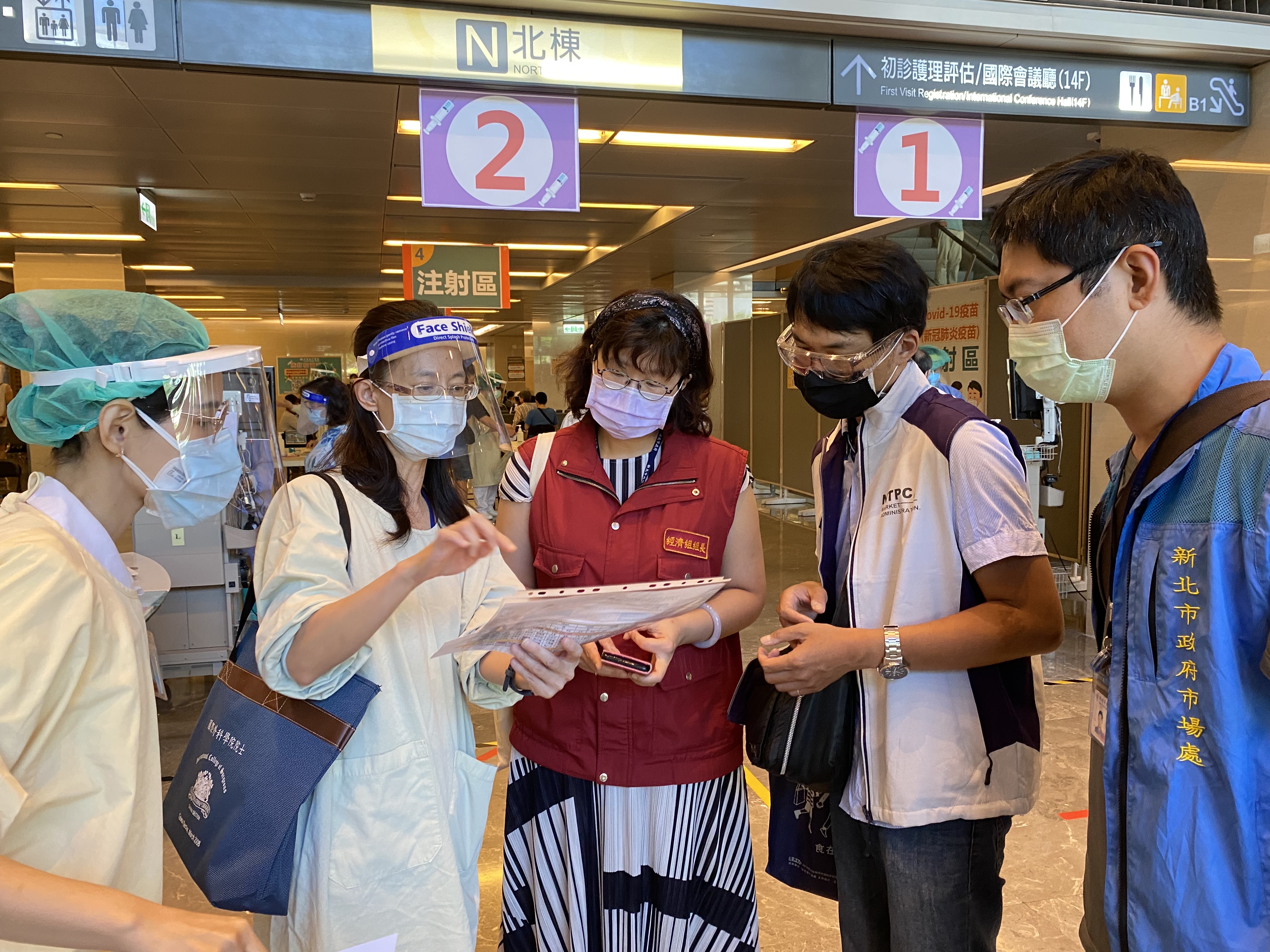 圖說：新北市政府經濟發展局長何怡明前往板橋亞東醫院疫苗接種站視察攤商接種秩序。