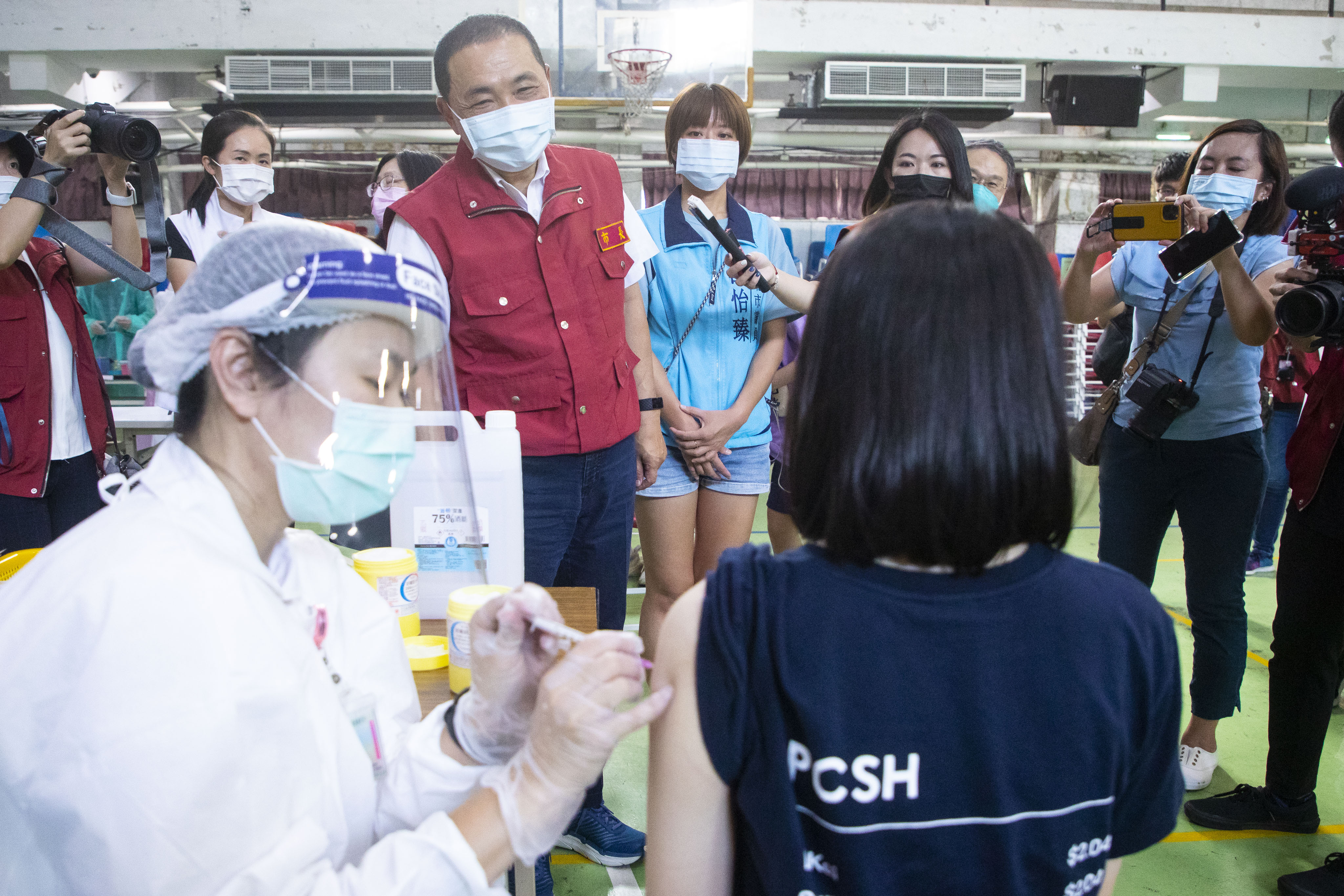 侯市長沿動線視察等待區、評估區、接種區及休息觀察區，提醒排隊時保持適當距離，並安撫同學緊張心情。