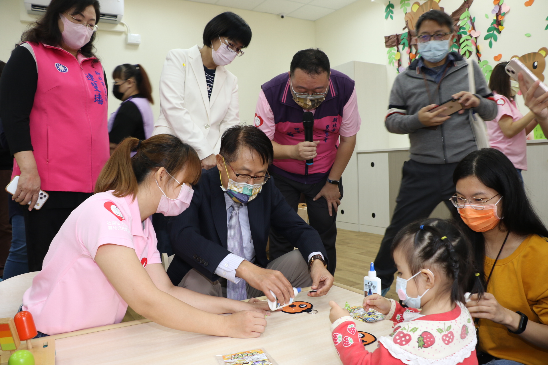 陳純敬和幼兒一起黏貼南瓜面具互動