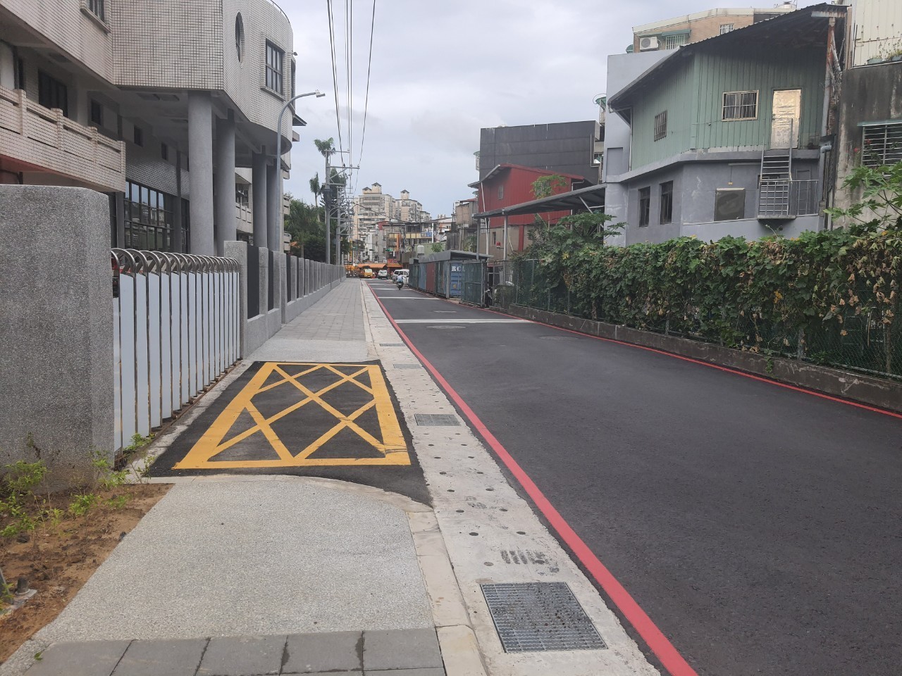 新泰國中行道在市府團隊推動下，退縮圍牆增加行人通行空間，一併將電桿、路燈及植栽帶位置整併至校園圍牆內，減少行人通行障礙，通學環境變寬敞了