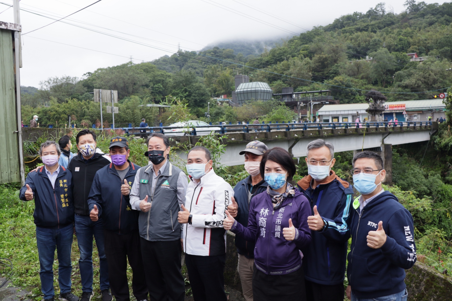 新北市長侯友宜和施工團隊、地方民代耆老和即將拆除重建的平菁舊橋合影留念