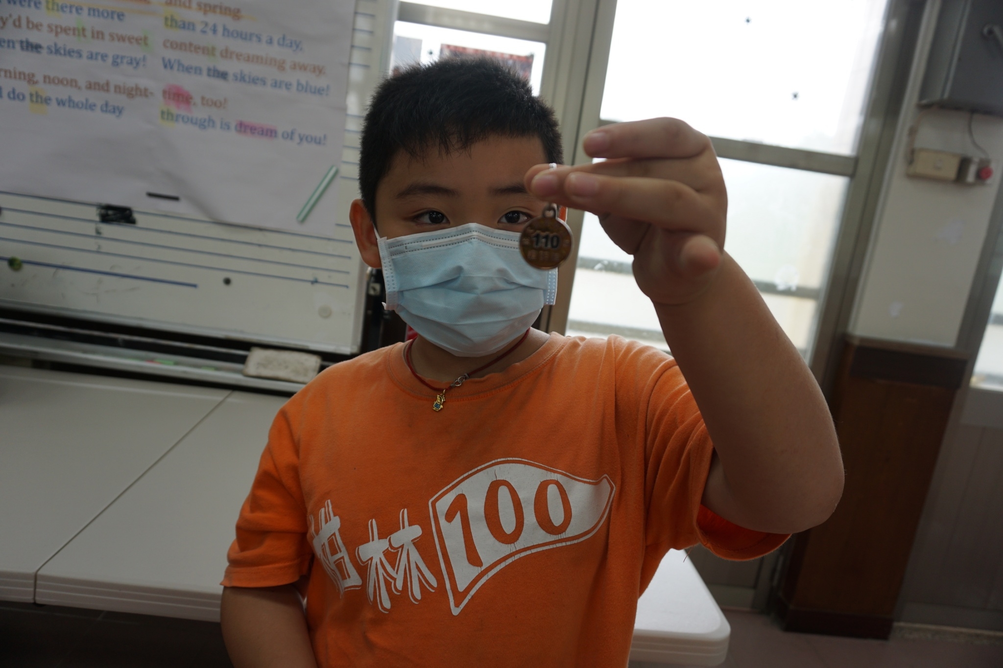 圖二、小學生手上拿的是今年度狂犬病疫苗注射證明金色頸牌。