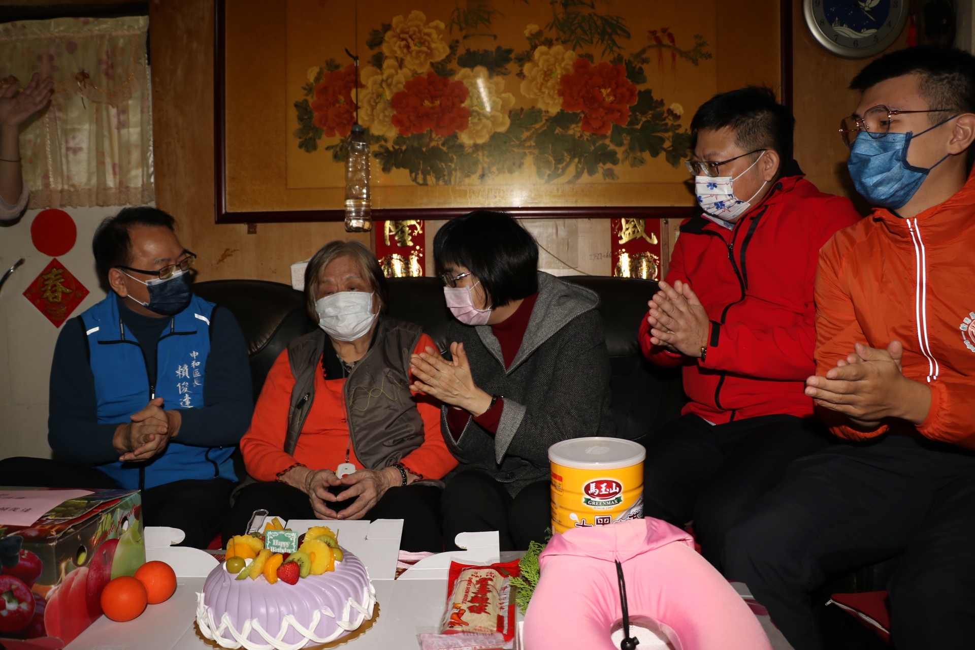 眾人獻上蛋糕、奶粉、長壽麵線  並齊聲為阿嬤唱生日快樂歌   左為中和區長賴俊達  右3為社會局長張錦麗  右2為中保社福基金會執行長洪培修  右1為齡活長照執行長彭紹宇