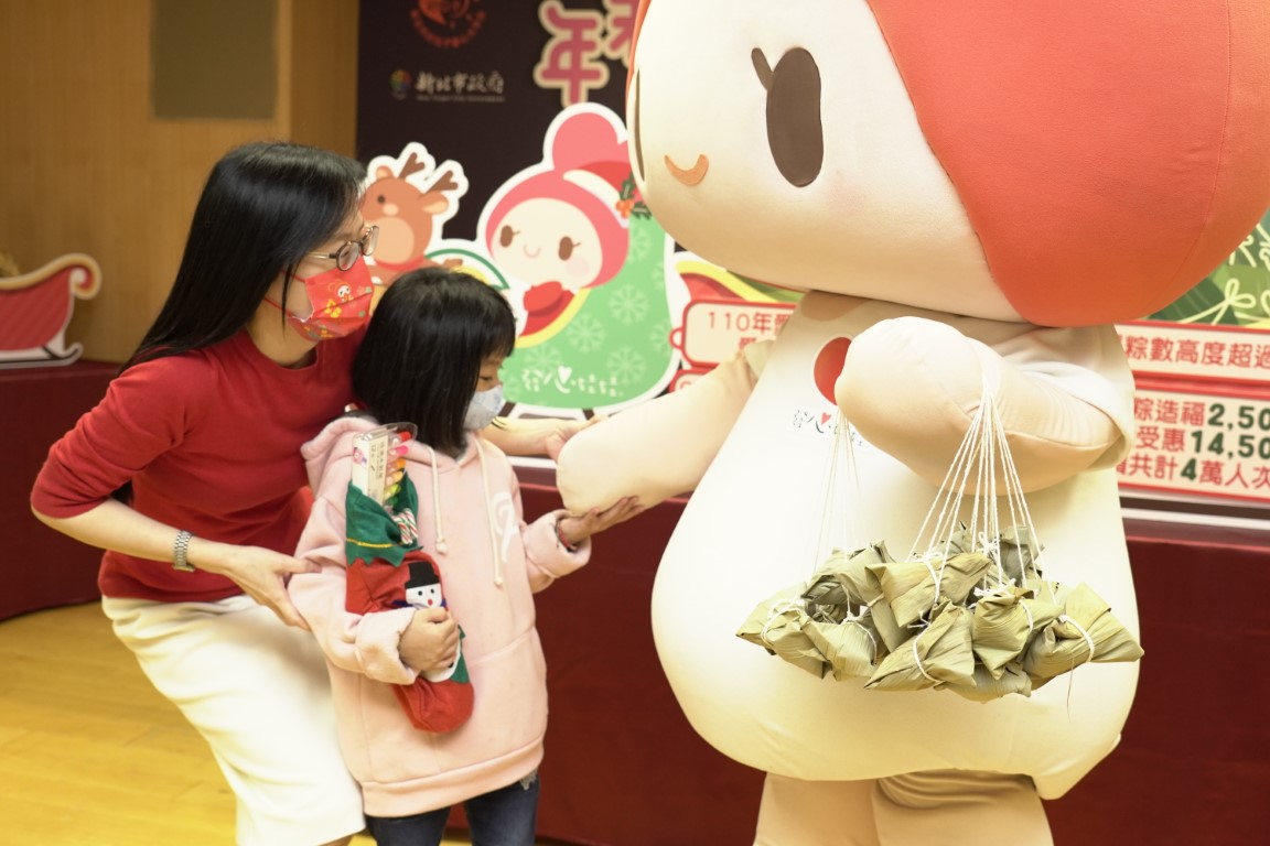 小雯的6歲女兒看到協會的玩偶發心娃娃  開心地向前牽手  左為中華道家人文協會理事長張旖