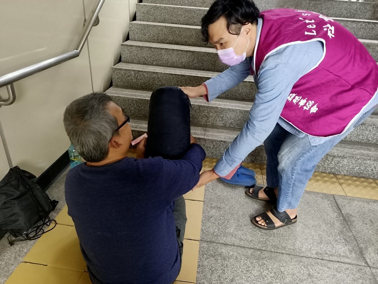 公所訪查人員趨前將物資提供街友並關懷身體狀況