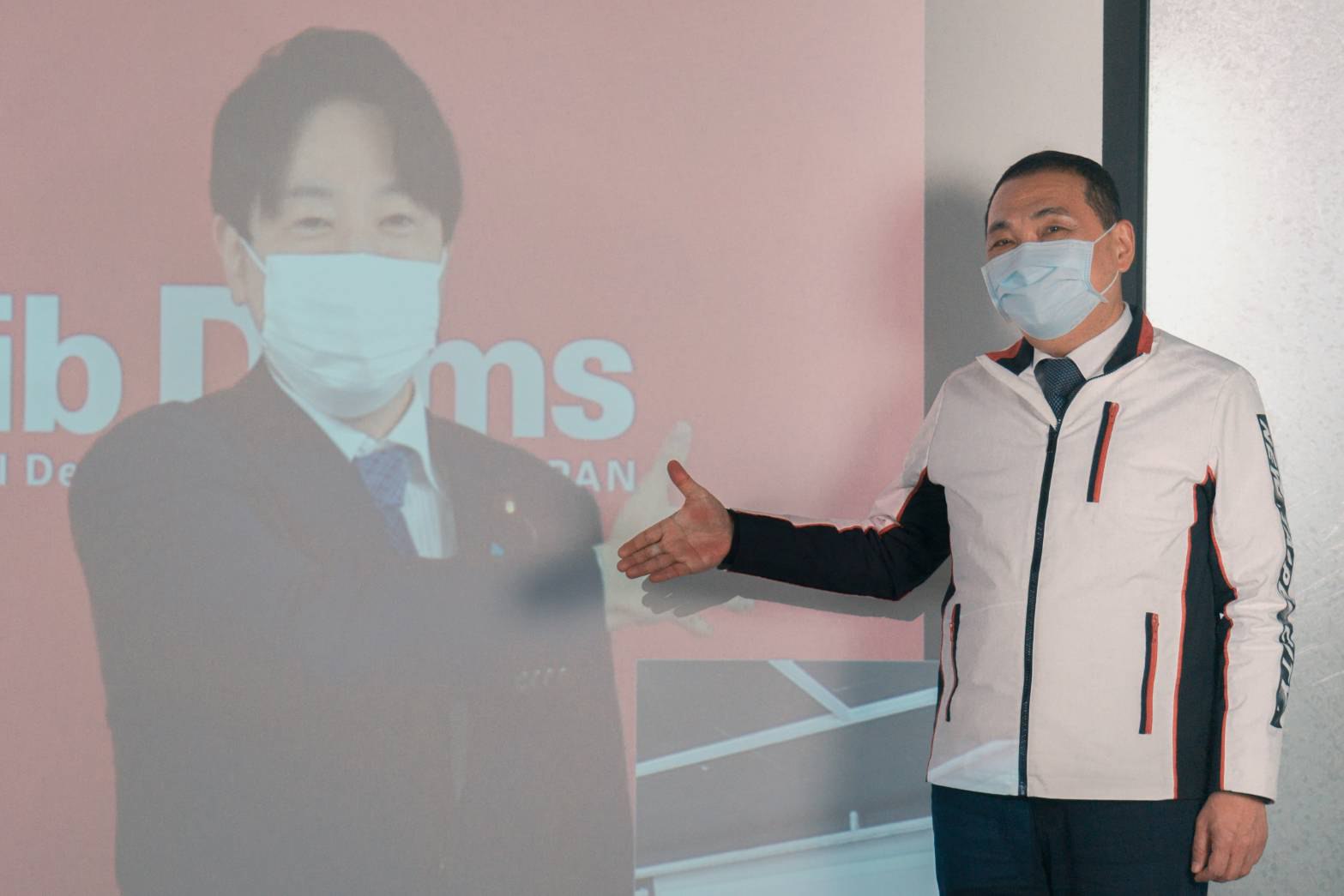 侯市長與自民黨青年局長小倉將信握手