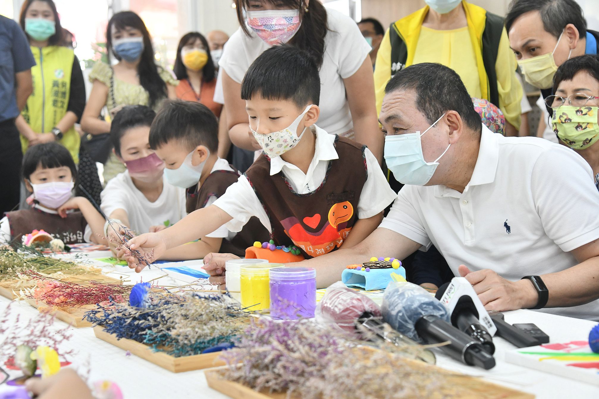 新北市立江翠國民中學今(15)日舉辦校舍改建啟用典禮，侯友宜參與幼兒園小朋友花瓶版畫手作課程，和小朋友一起挑選花藝材料。