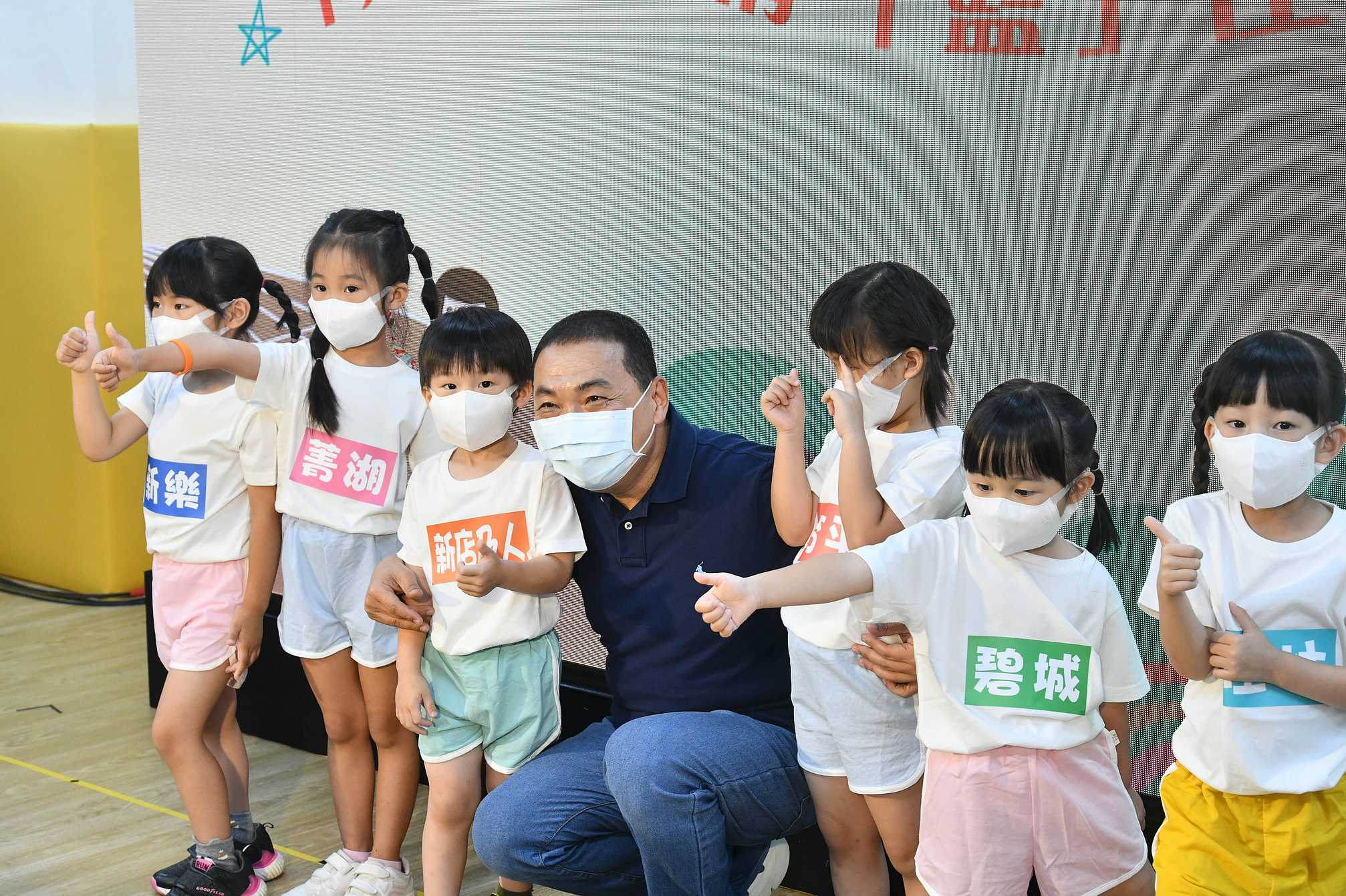 侯友宜與現場學童親切互動，以踢足球象徵「足」出疫情、傳球投籃象徵「籃」住幸福