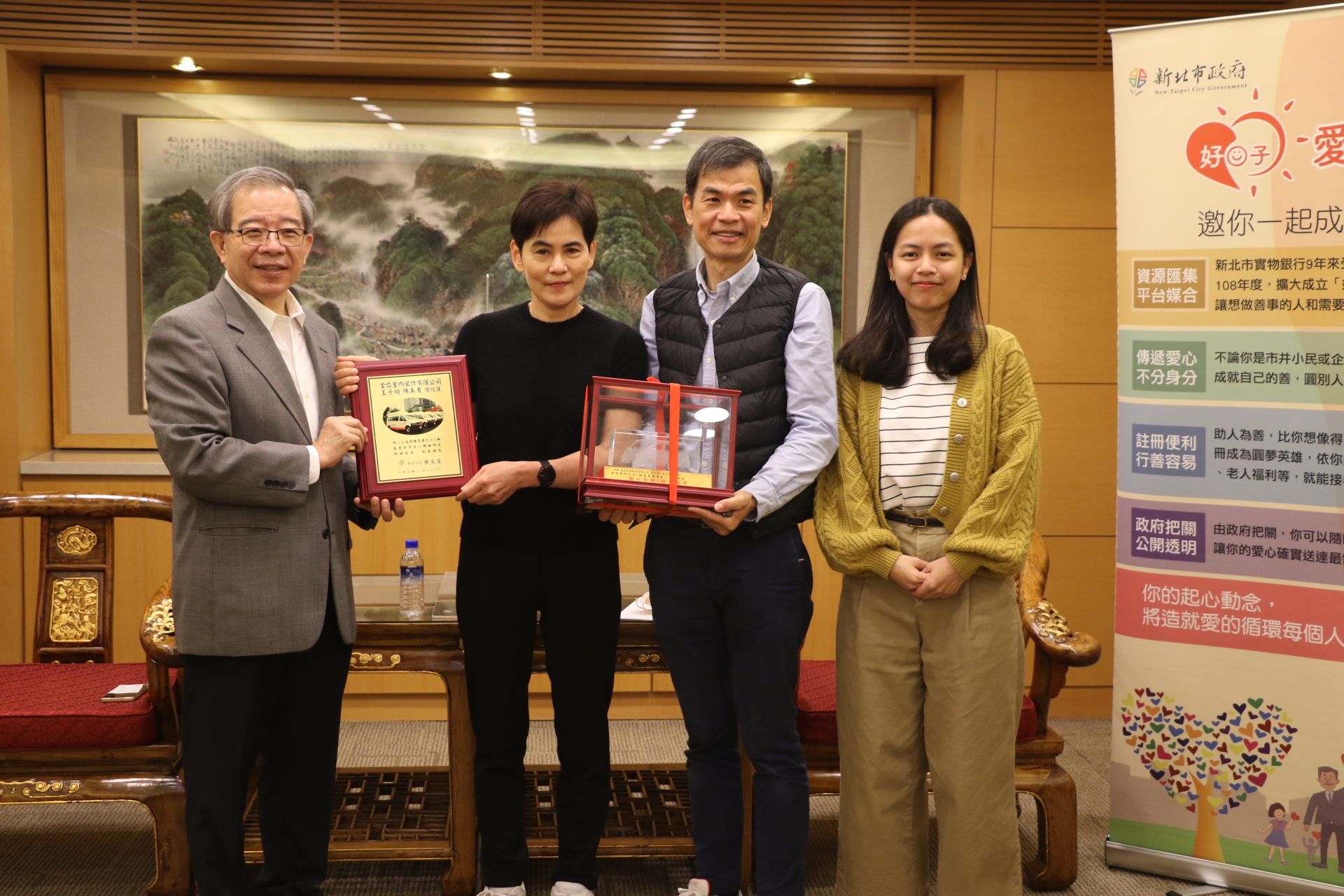 林祐賢秘書長代表侯友宜市長贈送感謝牌及復康巴士模型車給陳美貴（右3）和先生王子明（右2）及女兒